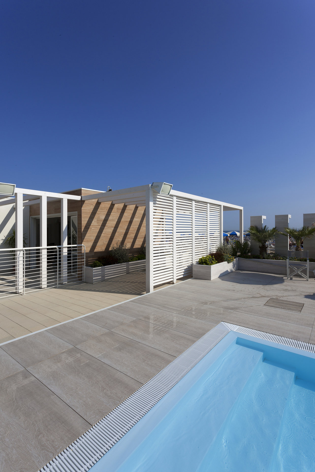 High-quality outdoor tiles on a sunny roof terrace with a pool.