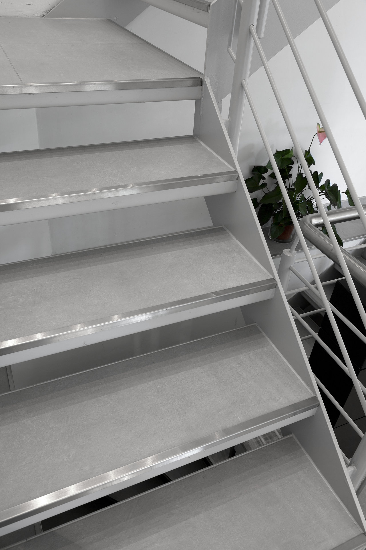 Timeless grey tiles on an indoor staircase with safety profiles.