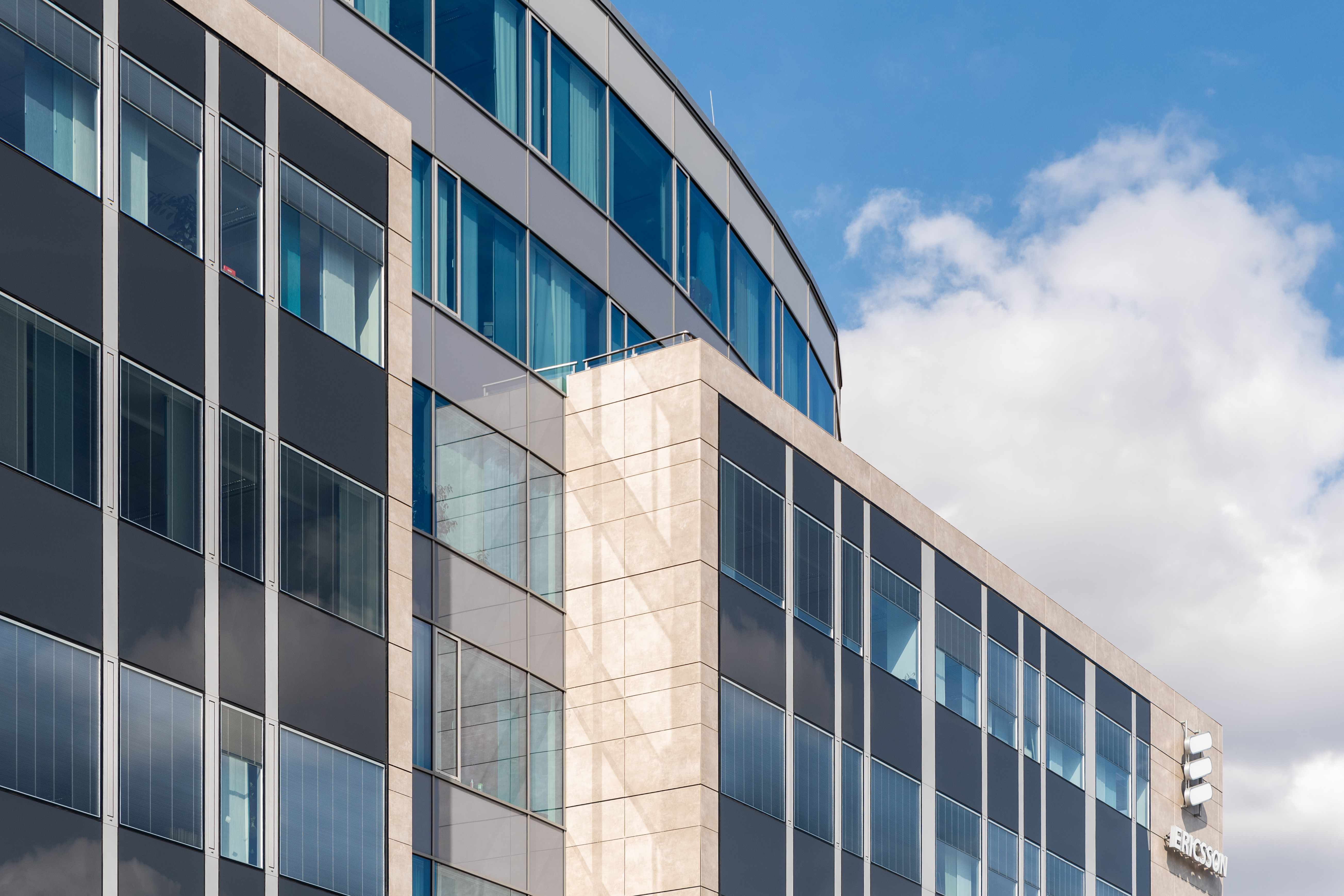 Modern building facade with dark and light ceramic or stone tiles.