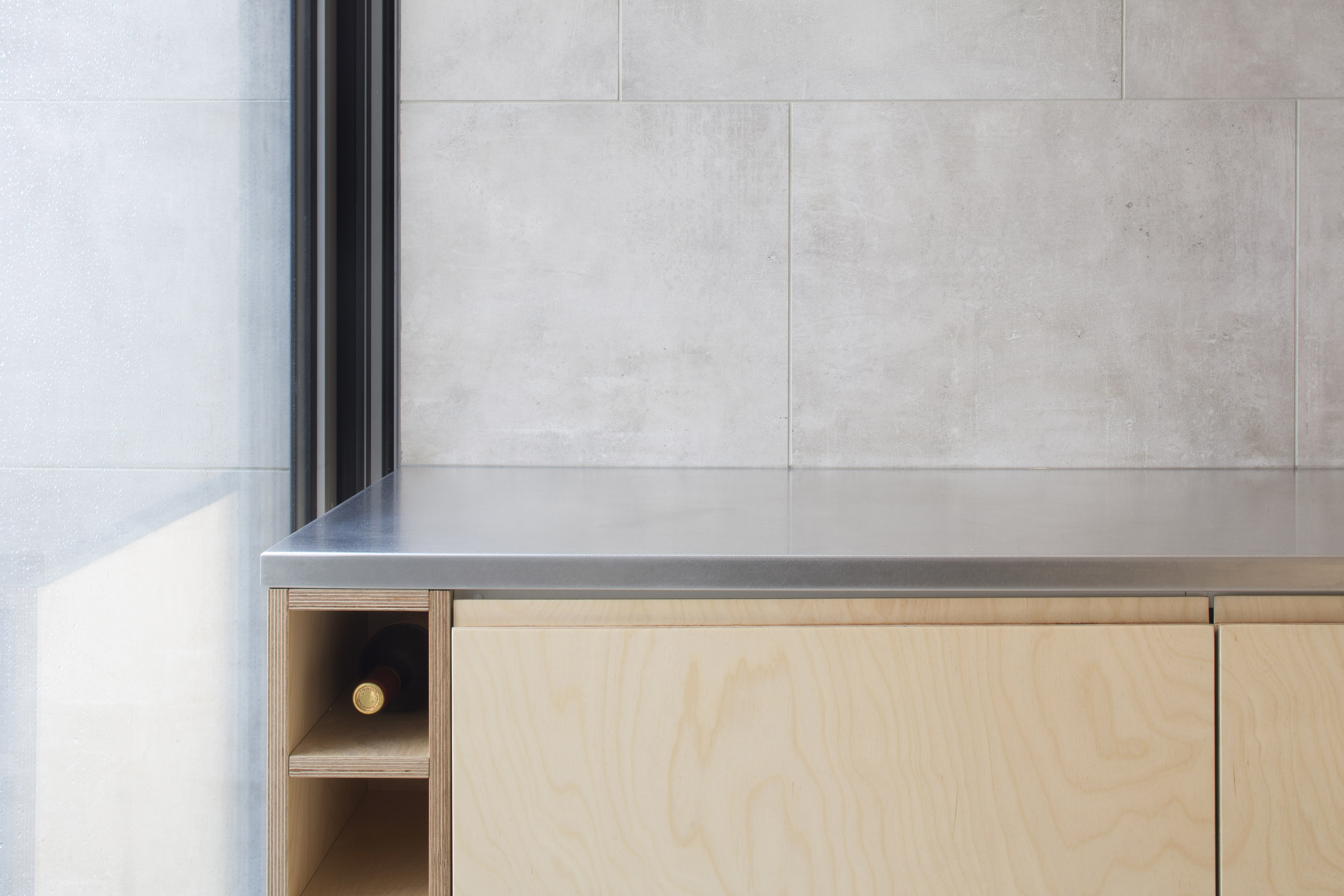 High-quality tiles in light concrete look as a modern kitchen splashback.