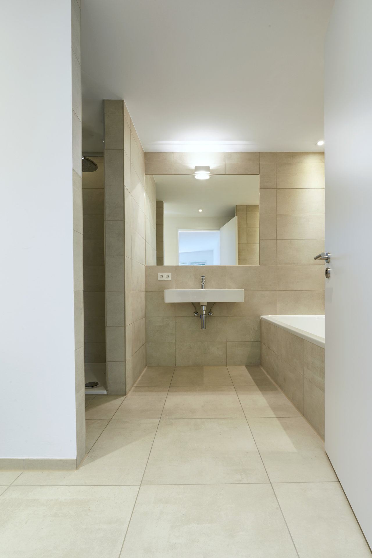 Elegant bathroom with premium beige large-format floor and wall tiles.