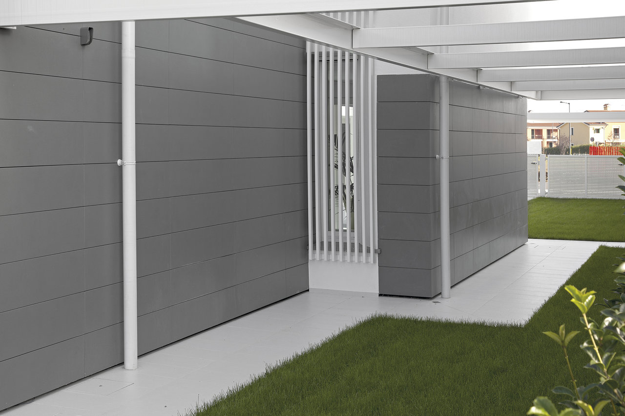 Light outdoor tiles create a modern outdoor path with grey walls.