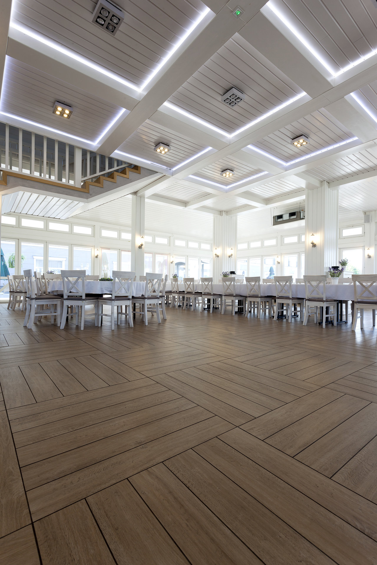 Elegant wood-look tiles by Porcelaingres in a bright, spacious ballroom.