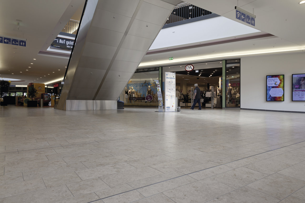 Large-format, light floor tiles in a modern mall.