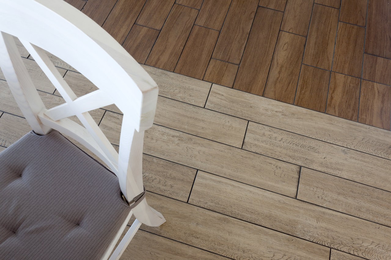 Wood-effect tiles, light & dark, diagonally laid, with chair.