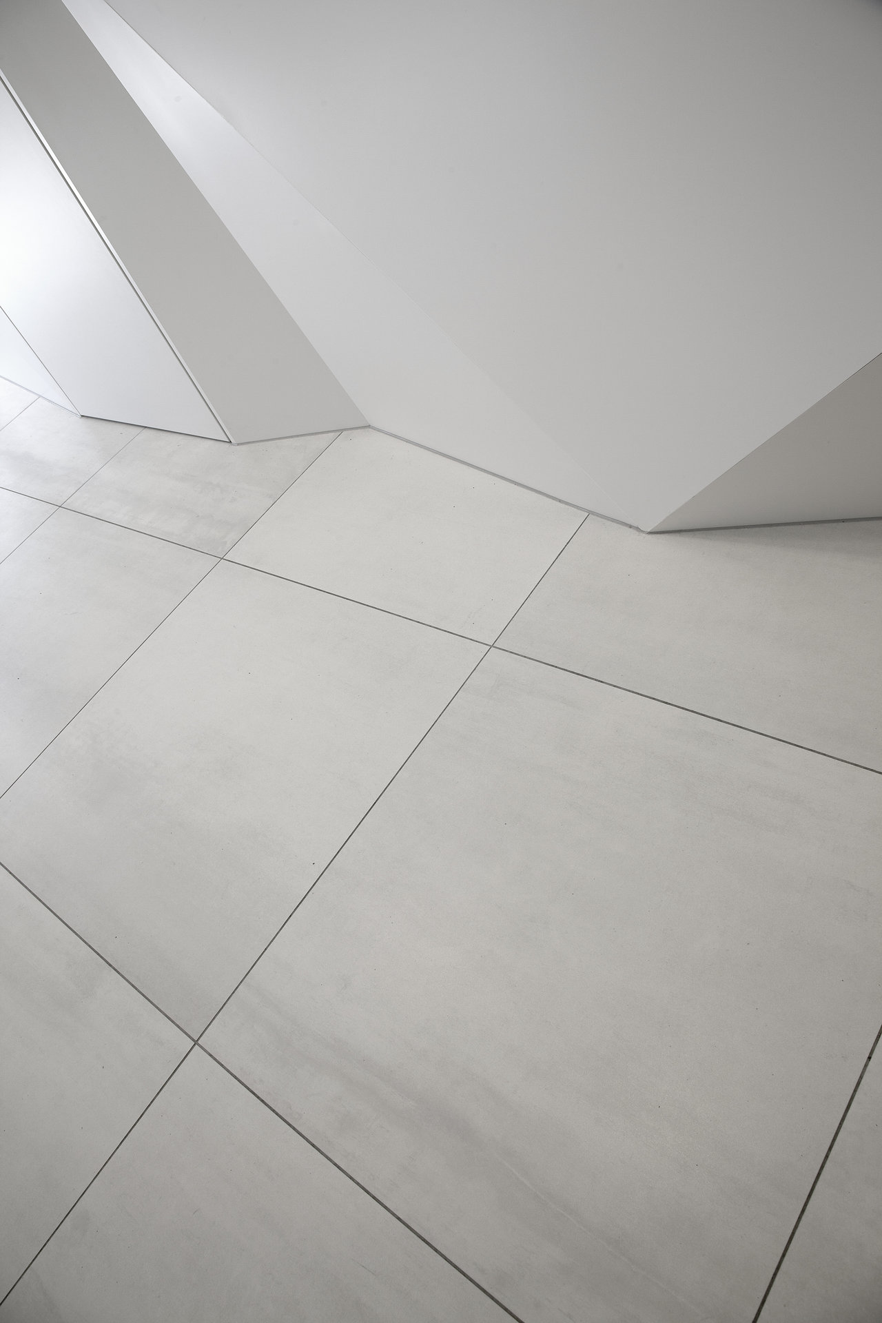 Modern, light, large-format floor tiles.