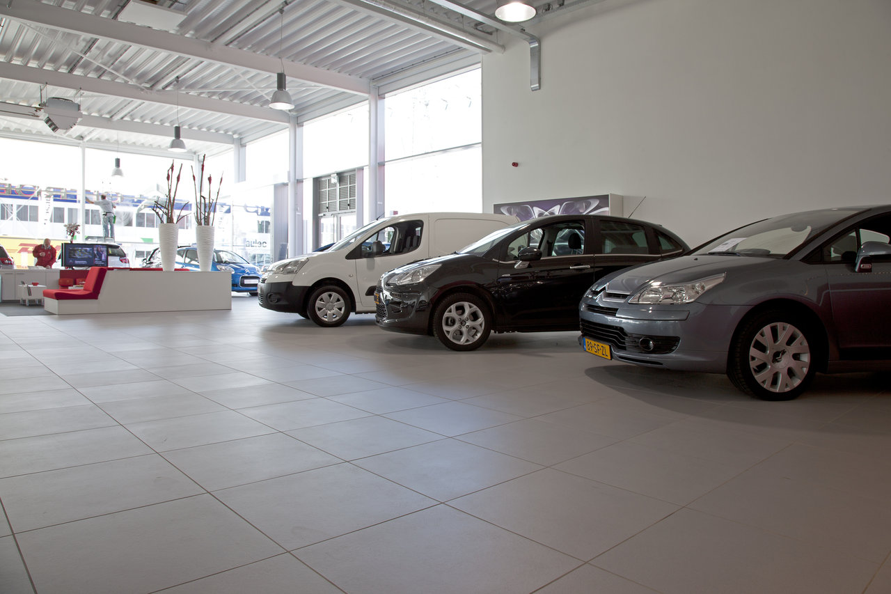 Premium, light-coloured floor tiles in a car showroom.