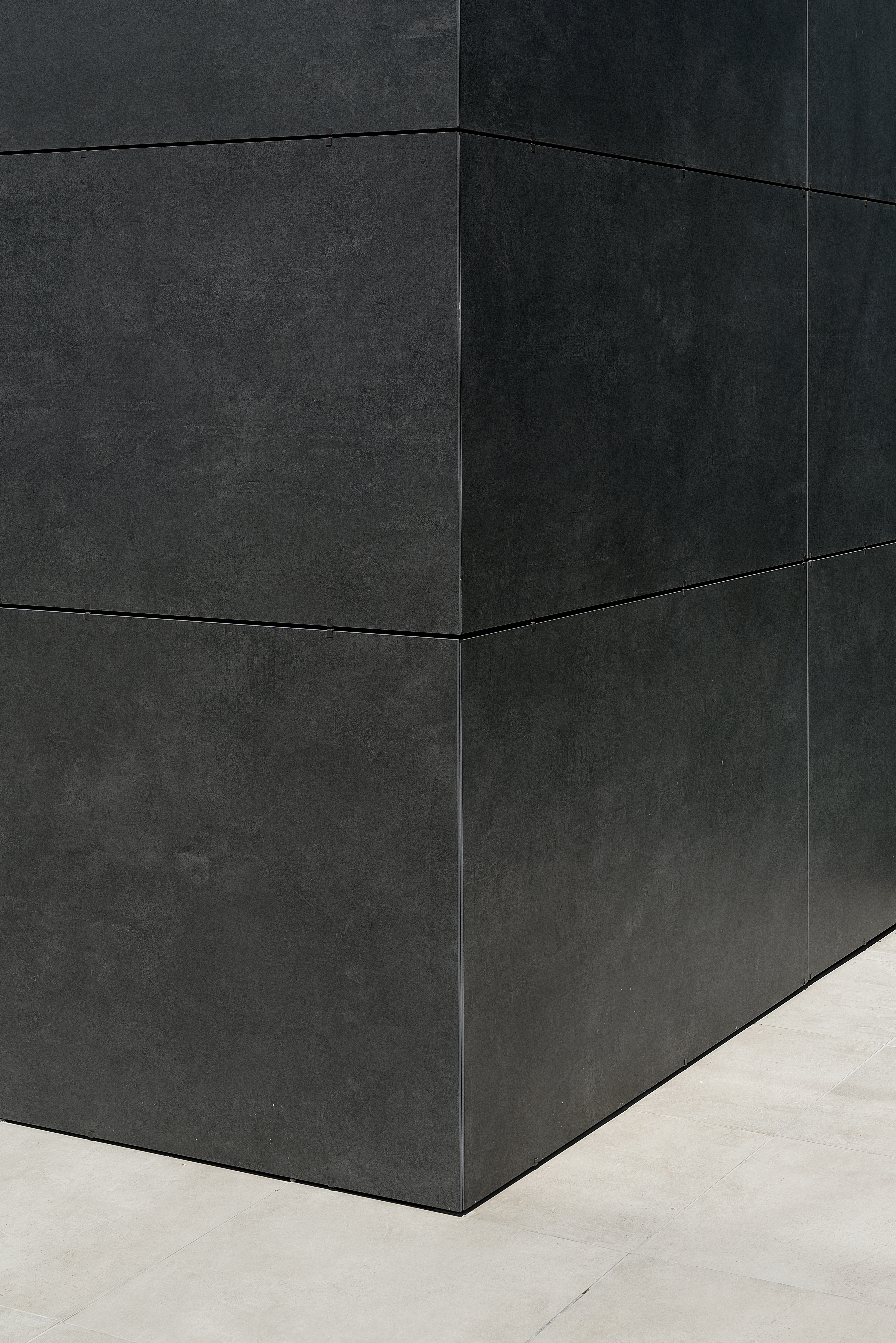 Large-format, dark grey concrete-effect tiles for modern indoor and outdoor areas.