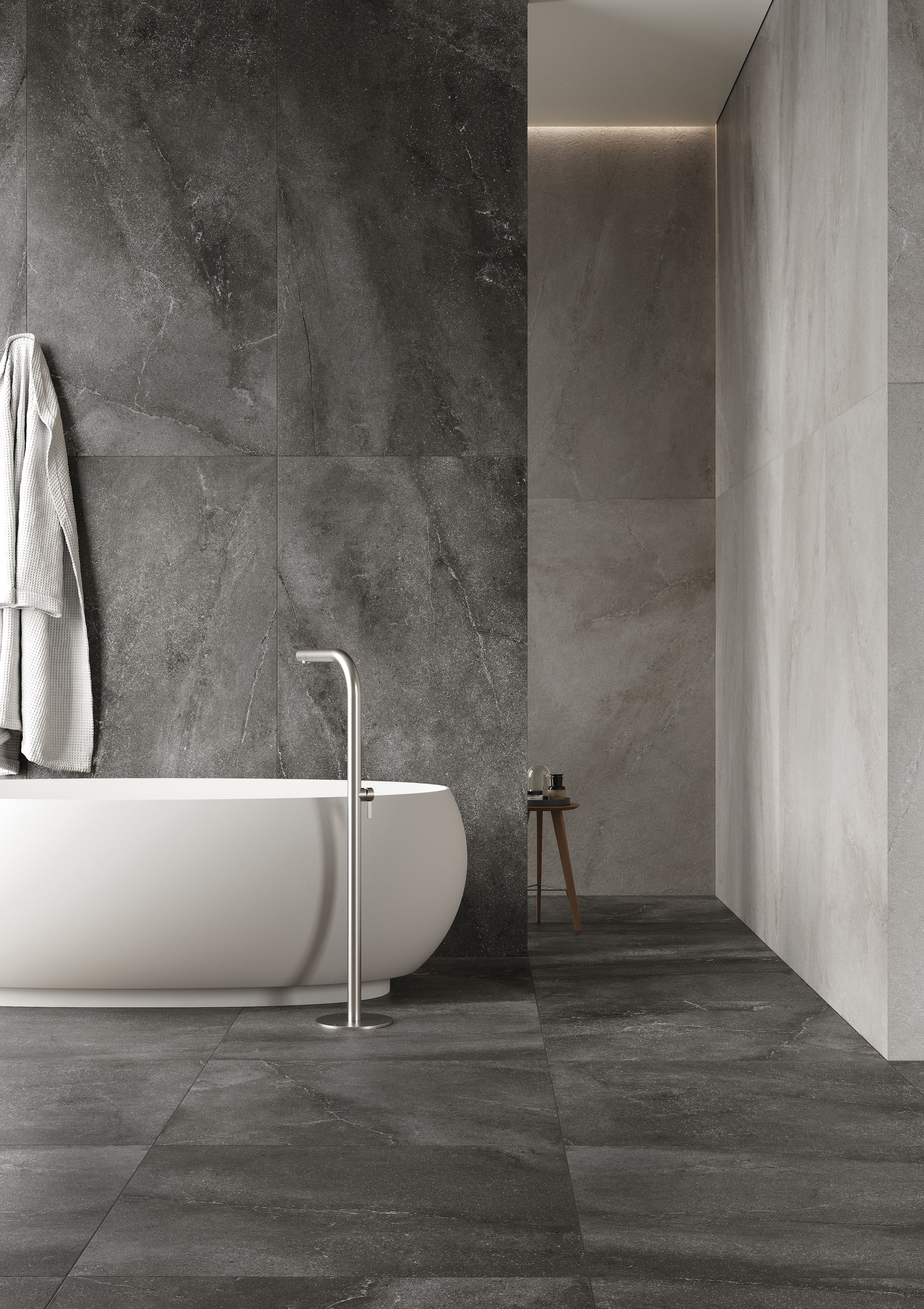 Elegant bathroom with large-format, dark grey tiles and modern freestanding bathtub.