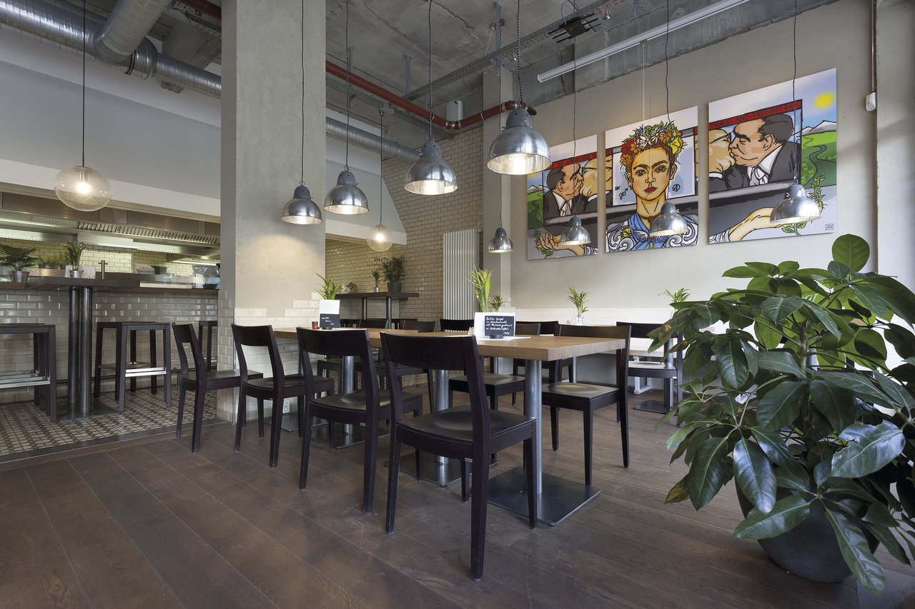 Dark wood-effect tiles in restaurant with modern industrial design.