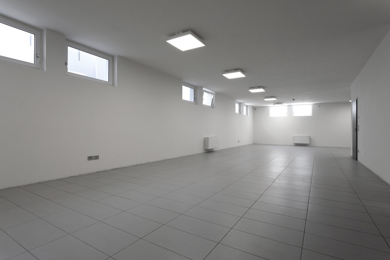 Bright, empty room with modern light grey floor tiles and white walls, ideal for new design.