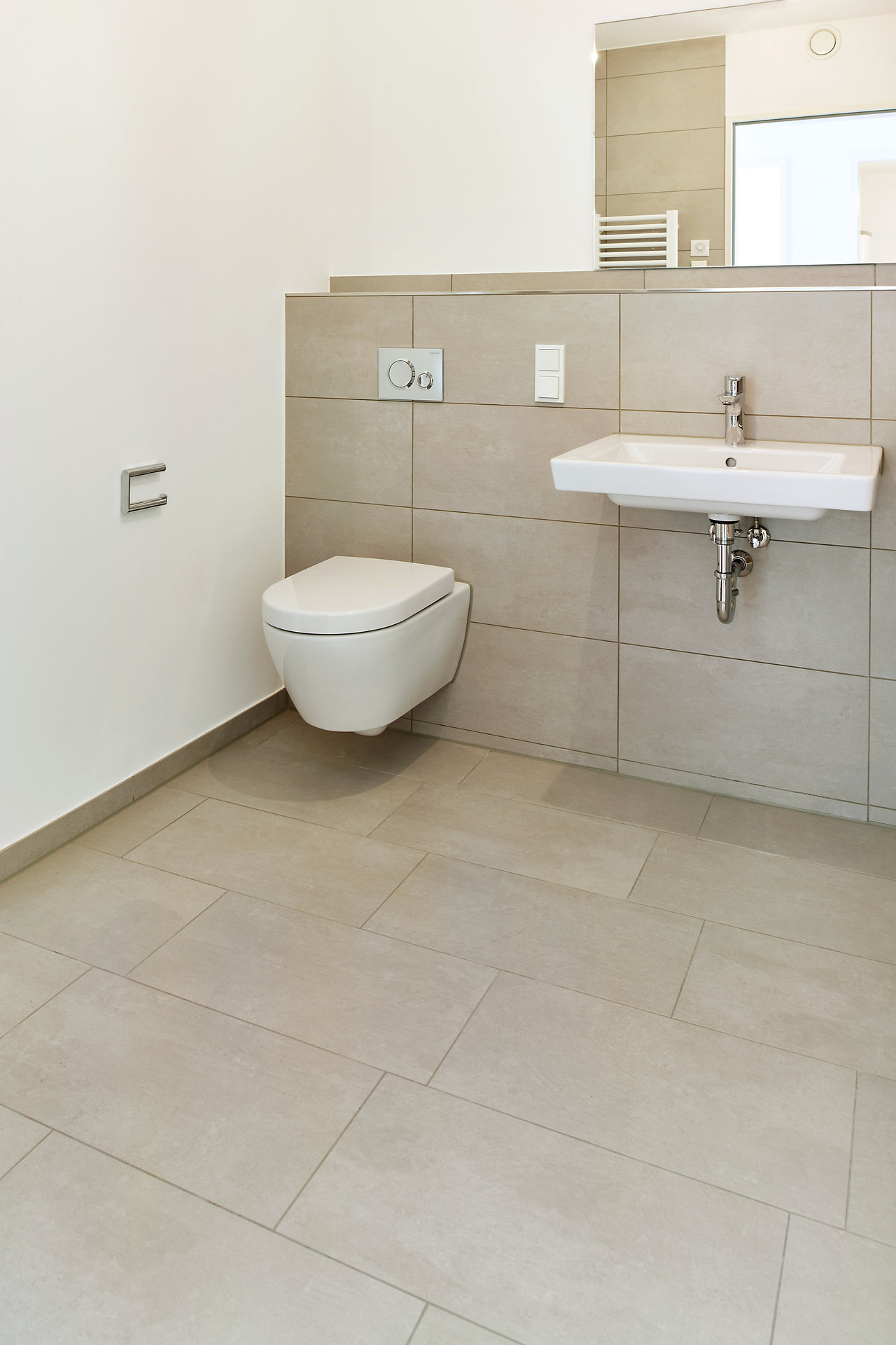 Modern bathroom with bright, large-format tiles on floor and wall.
