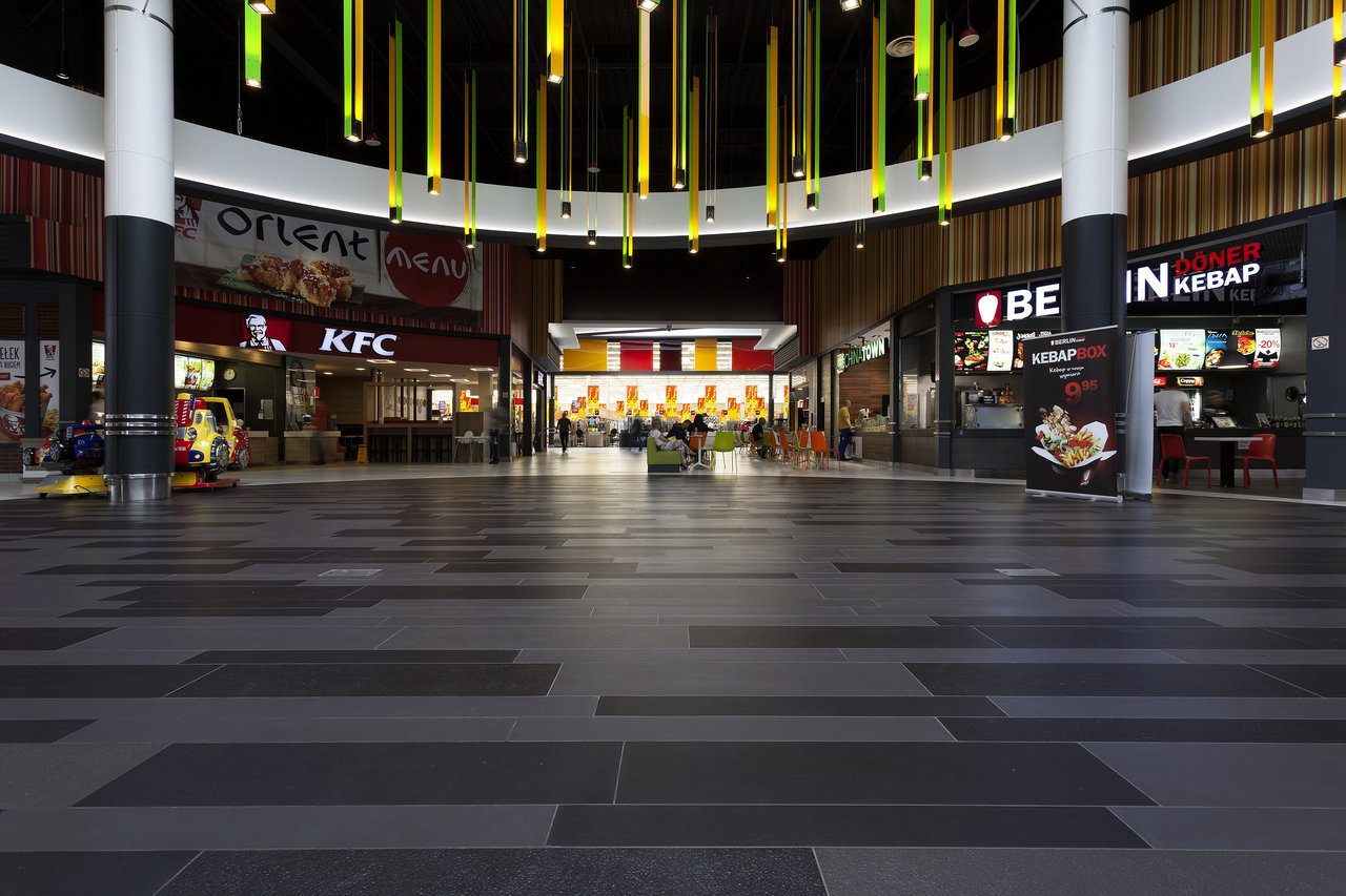 Modern grey and anthracite tiled floor in a shopping centre.