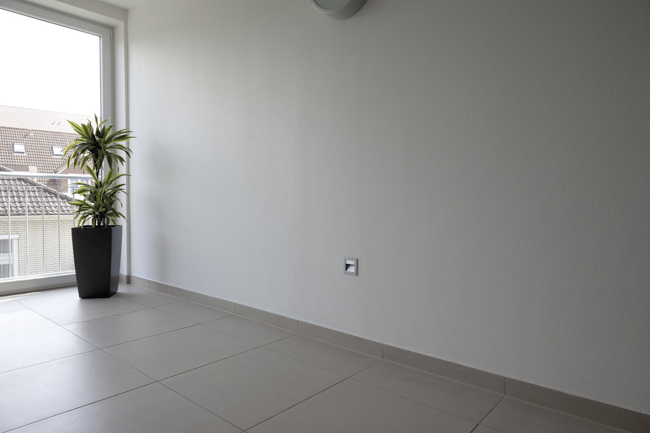 Large-format, bright tiles on a balcony, ideal for indoor and outdoor use.