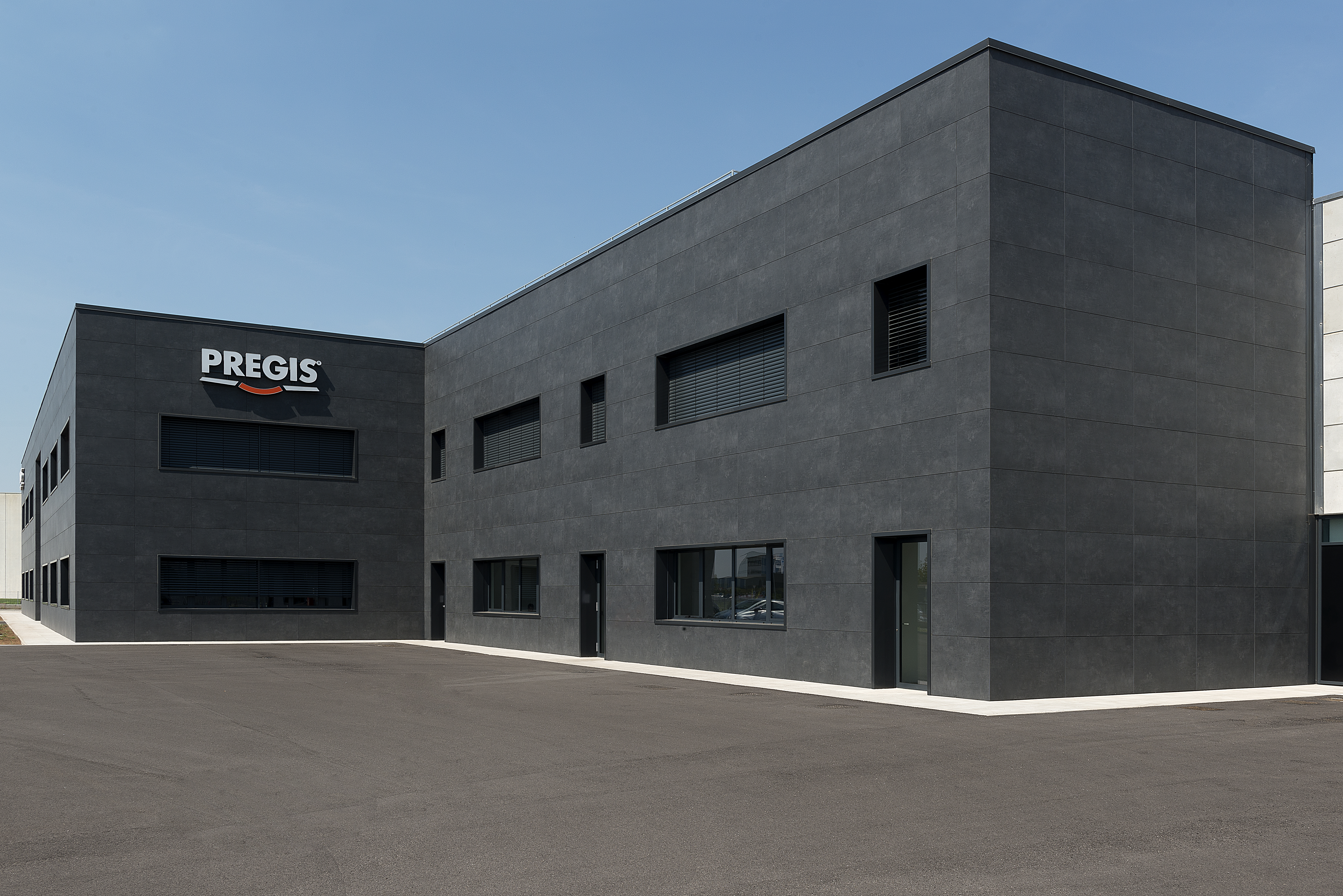 Modern dark grey corporate building with PREGIS logo and large forecourt.