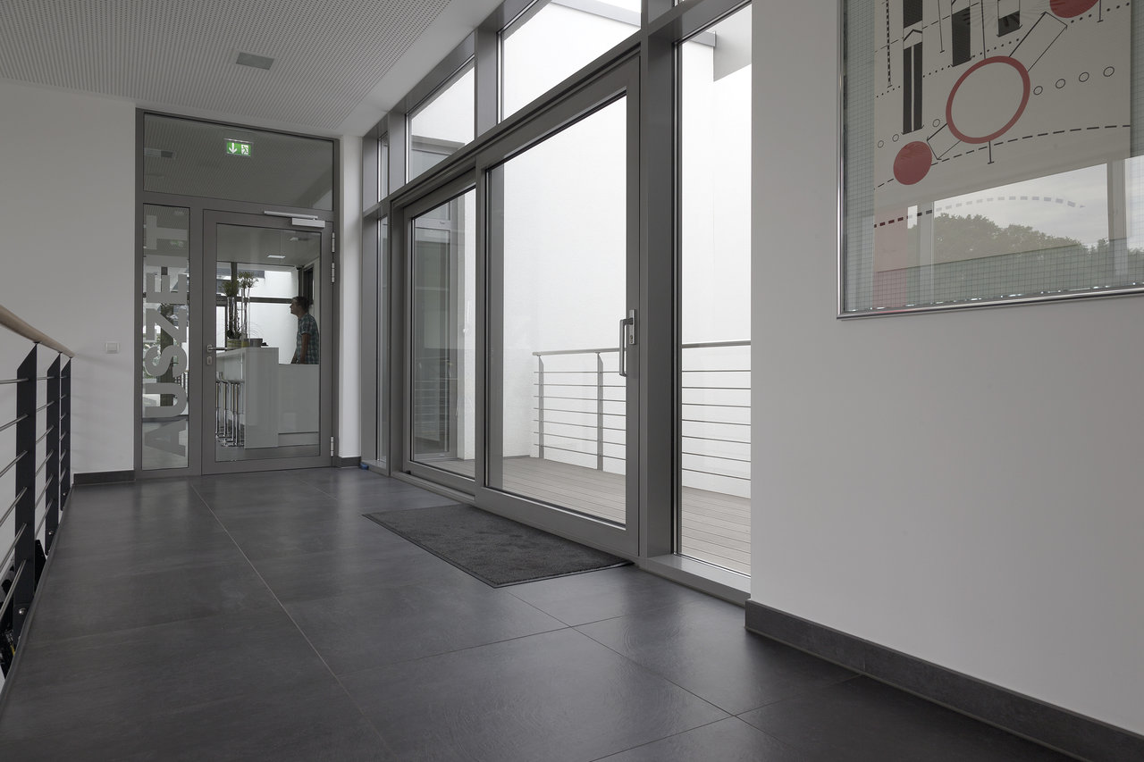 Modern anthracite tiles in a hallway with balcony access.