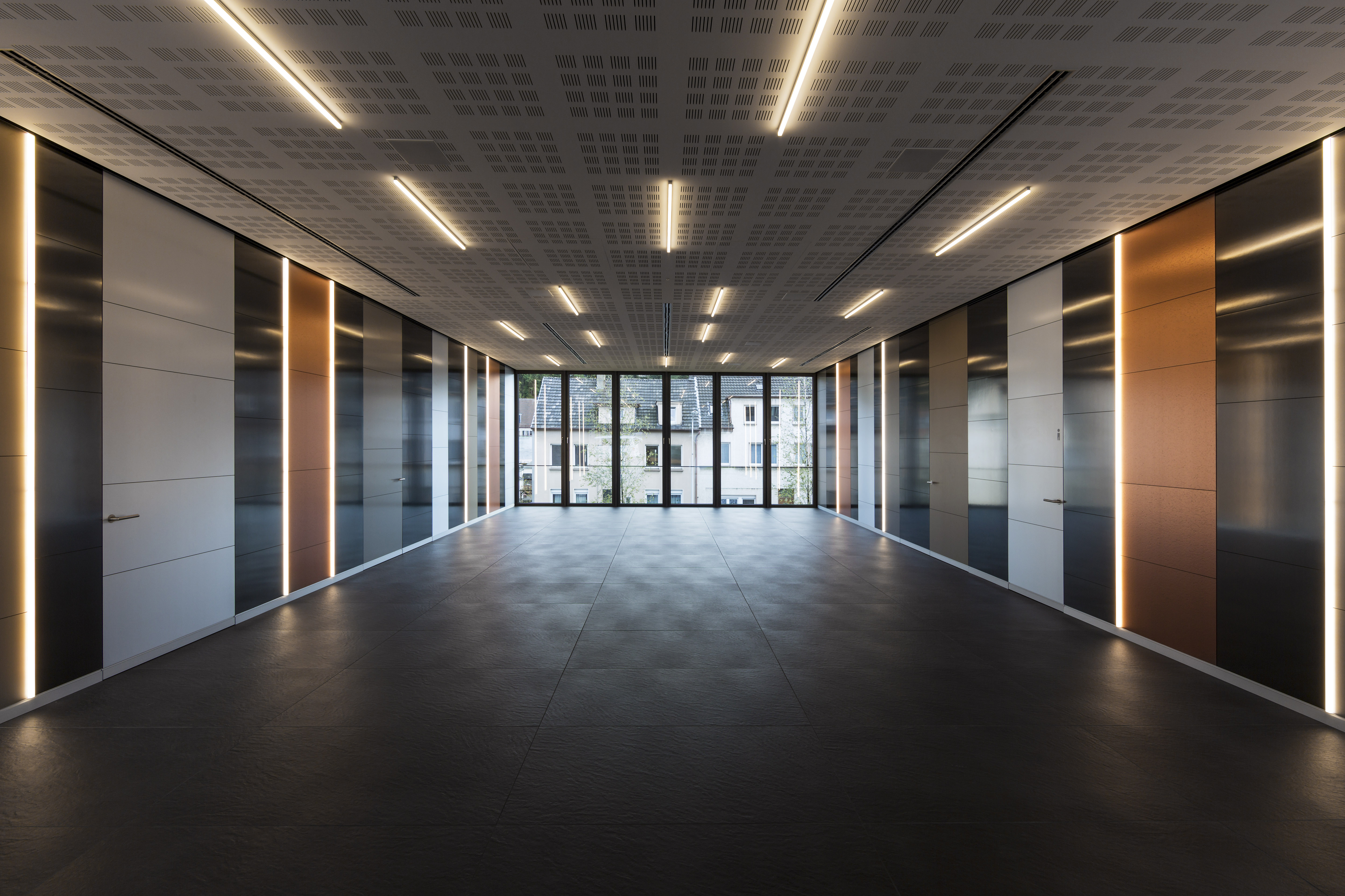 Modern room with dark tiled floor and stylish lighting.