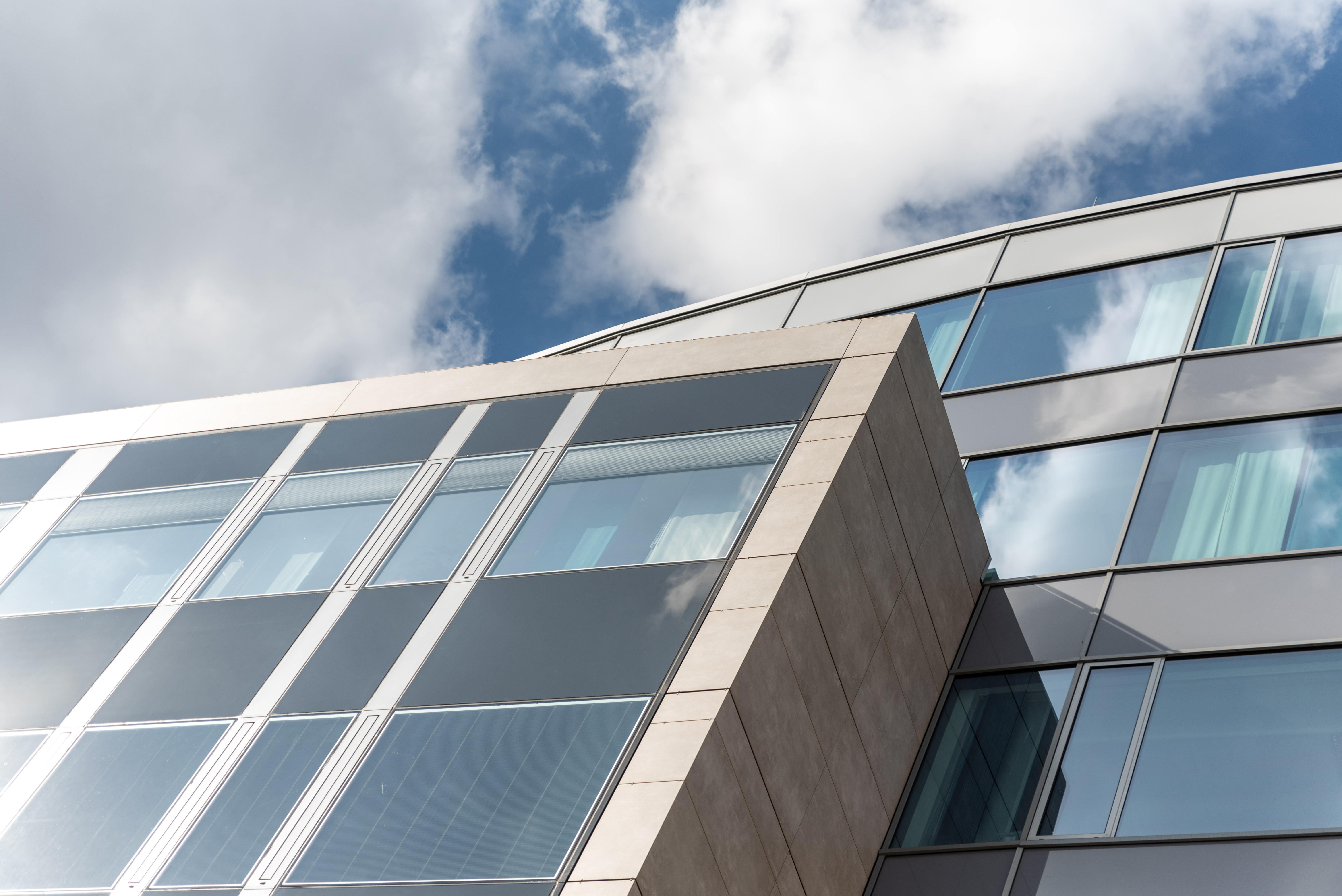 Angled view of a modern glass and stone building facade.