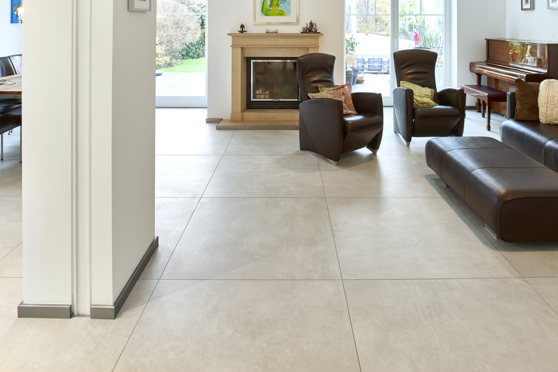 Large, light grey tiles in stylish living room with fireplace.