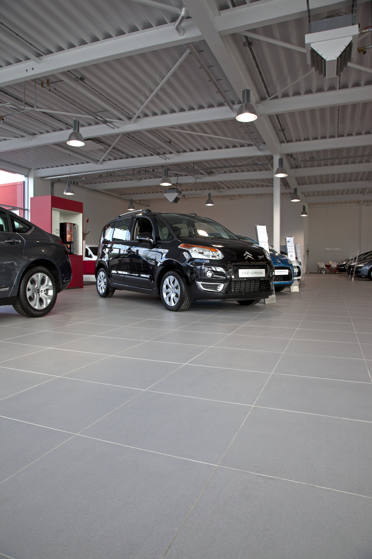 Modern, large-format grey tiles in a car dealership, ideal for high-traffic indoor areas.