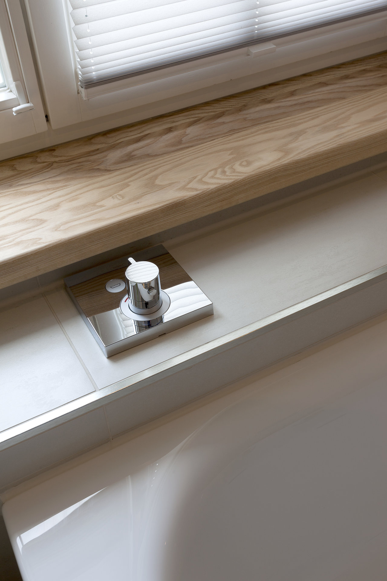 High-quality white tiles around a bathtub with chrome fittings.