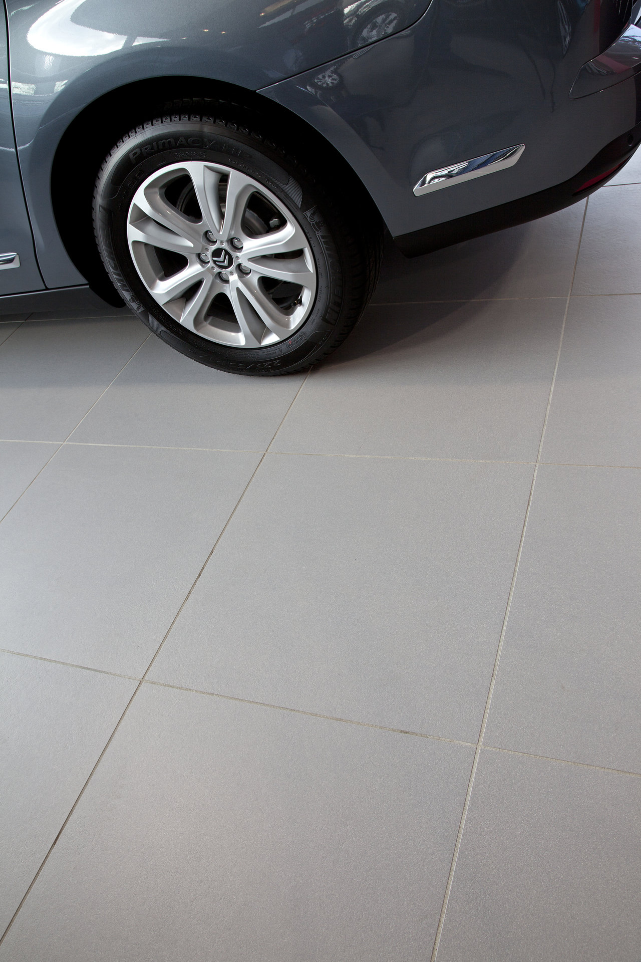 Modern, light grey tiles, durable for indoor areas like garages.