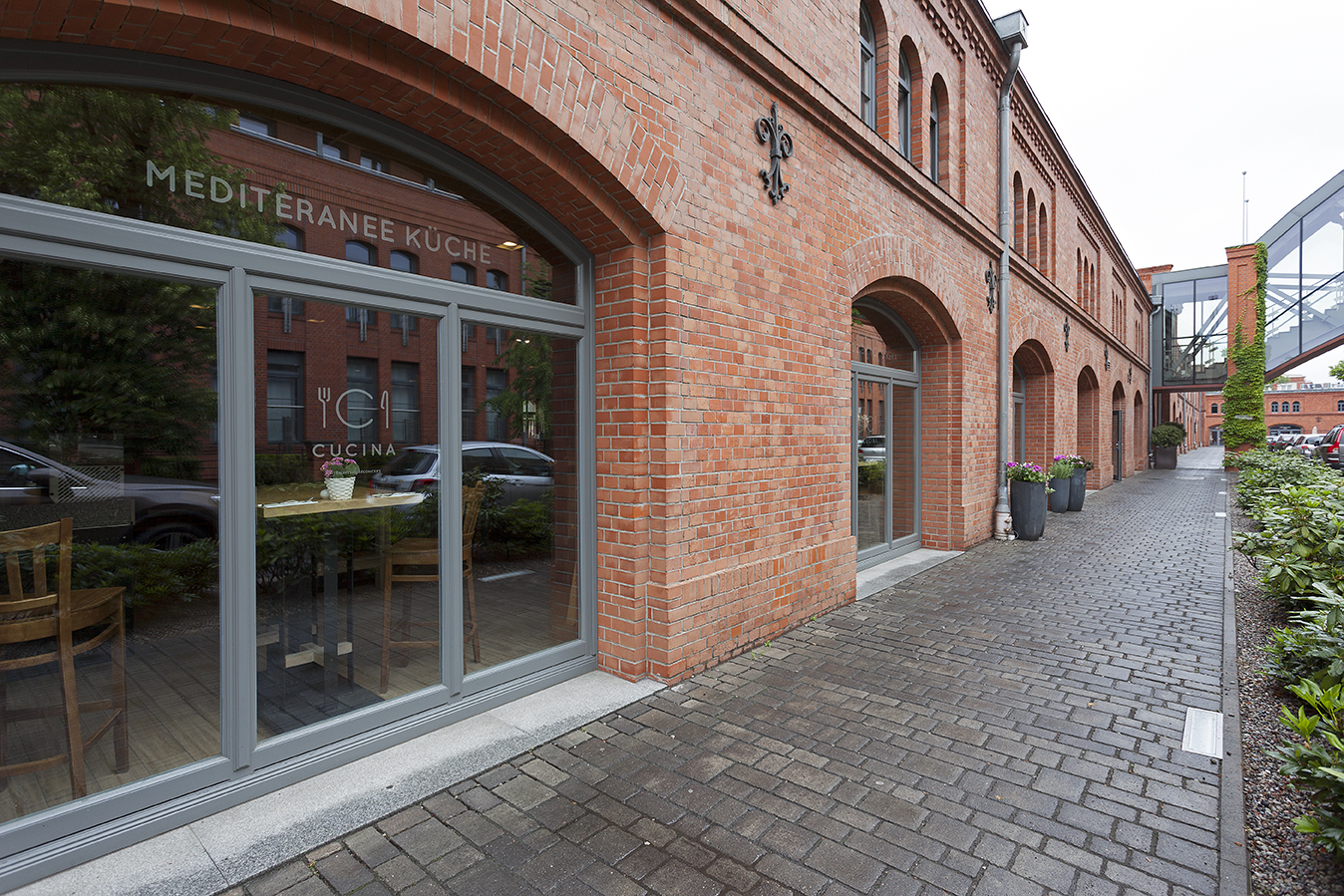 Paved walkway in front of a historic brick building – Outdoor tile inspiration.