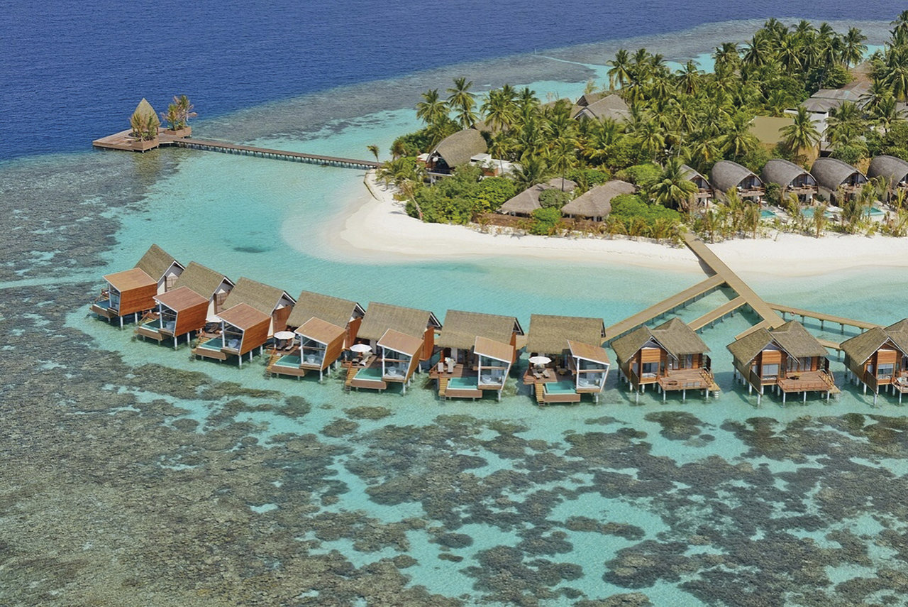 Aerial view of a tropical island resort with water villas and beach, perfect for outdoor tiles.
