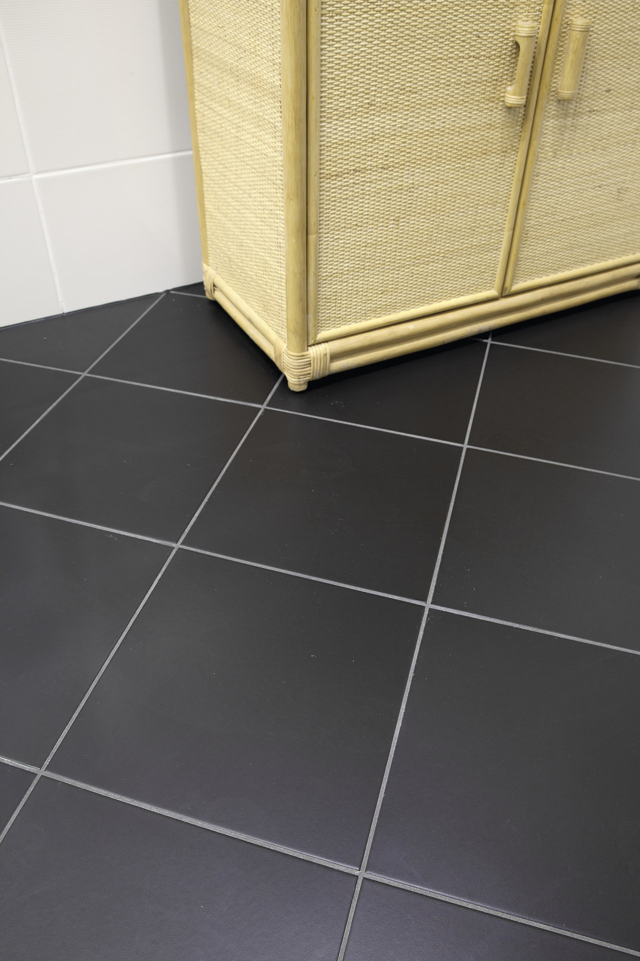 Dark square floor tiles with light grout for modern interiors.