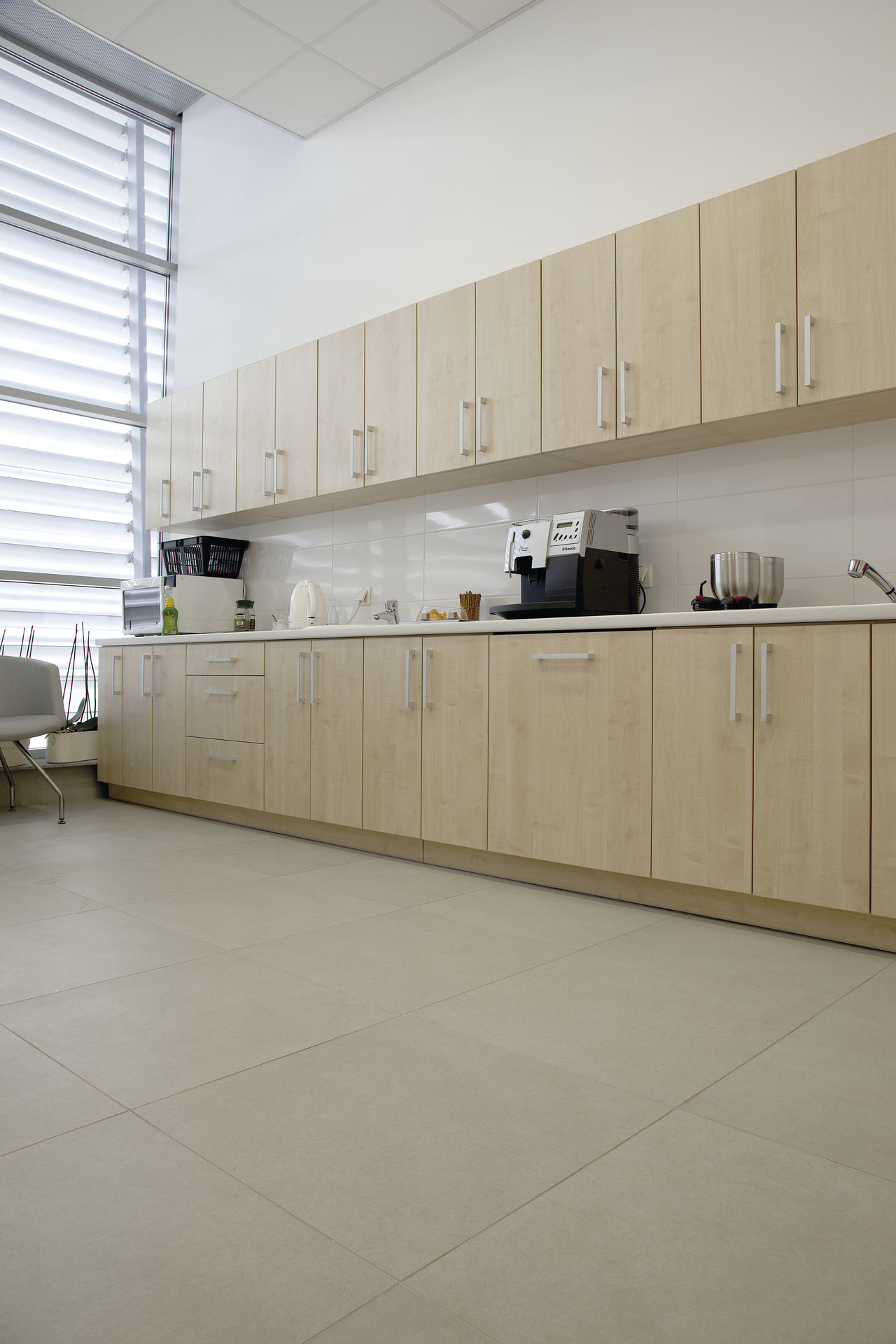 Bright, large-format floor tiles in a modern kitchen.