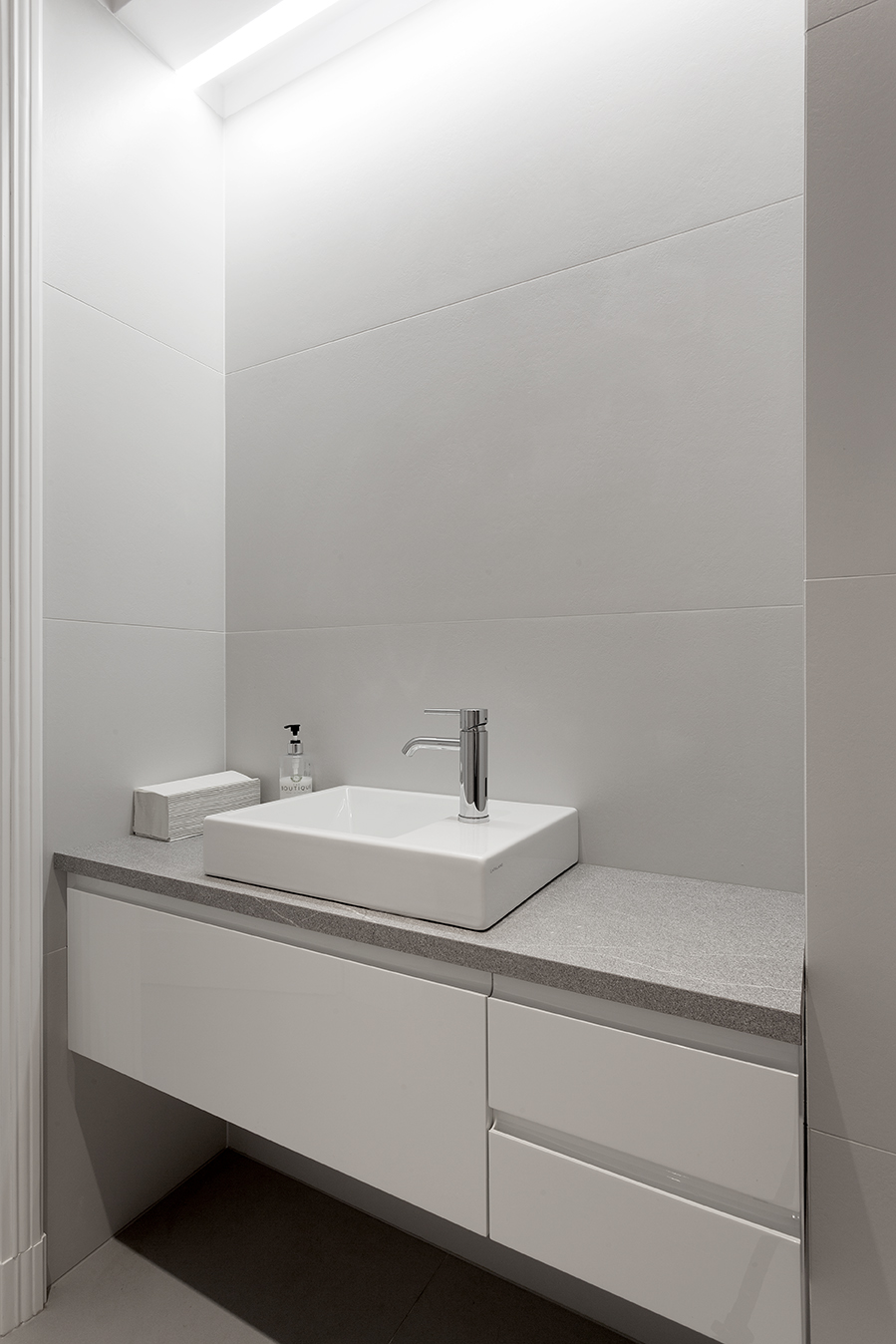 Bright bathroom with large-format grey wall tiles and modern vanity.