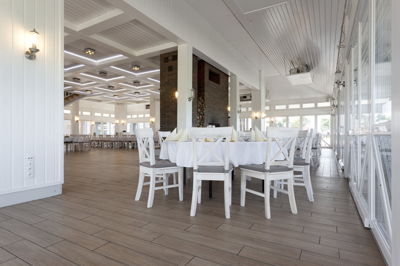 Bright room with elegant wood-look tiles and white-set tables.