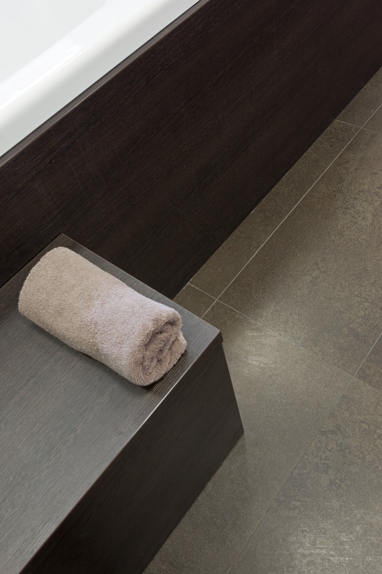 High-quality dark grey floor tiles and dark wall tiles in a modern bathroom.