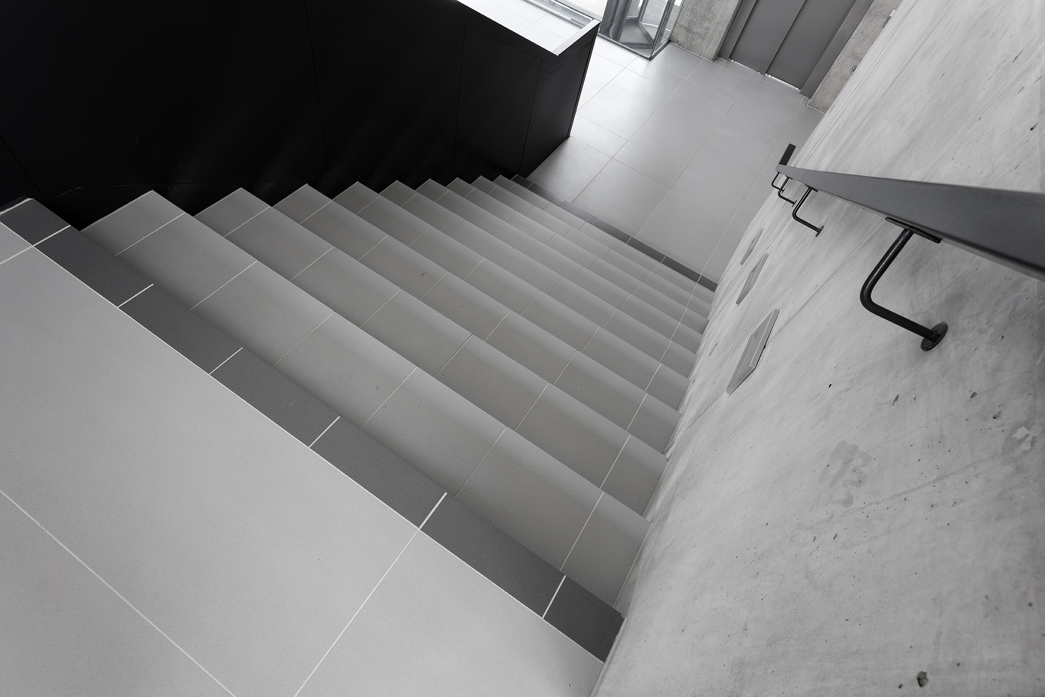 High-quality grey tiles on a modern indoor staircase.
