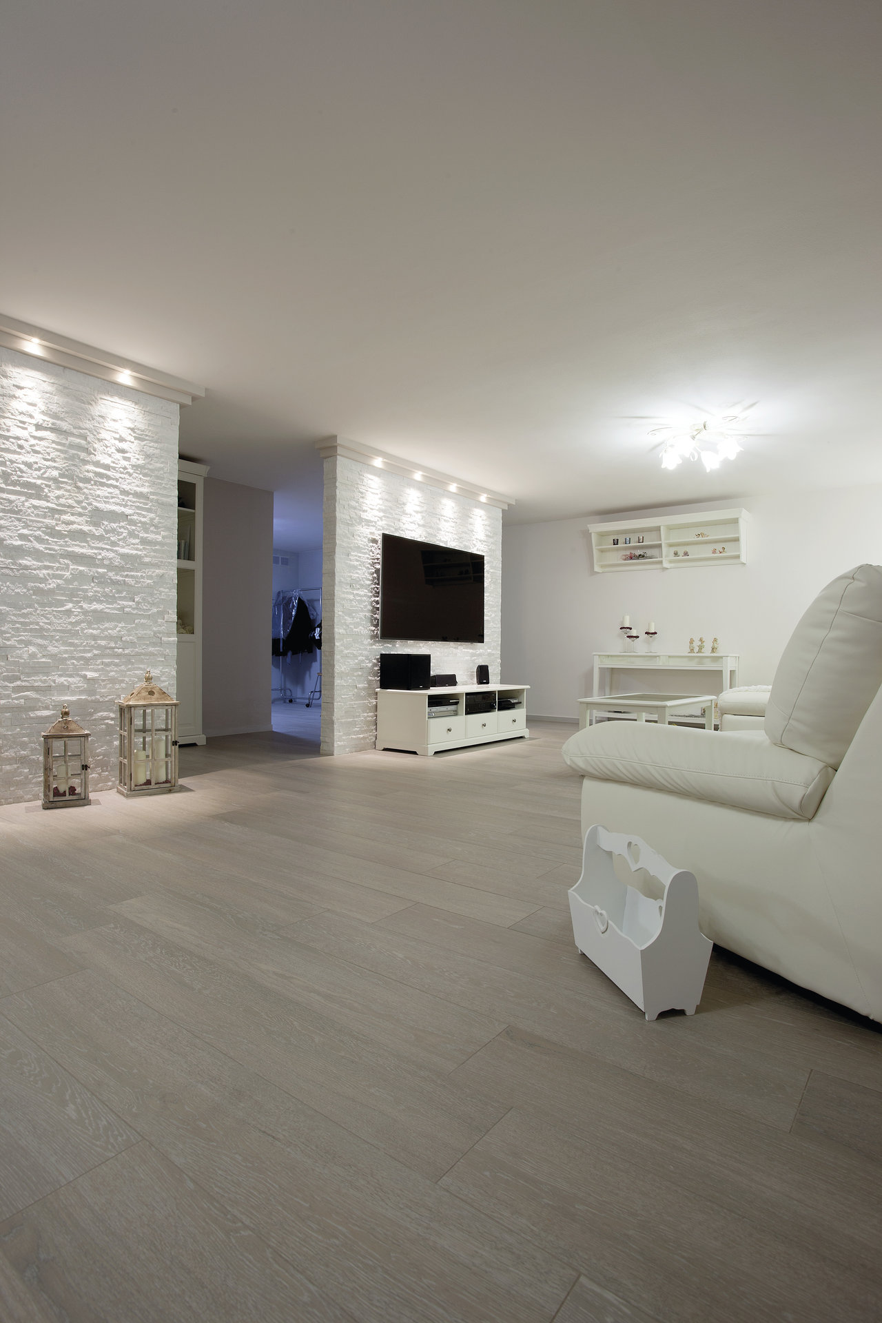 Spacious living room with stylish, light grey wood-effect floor tiles.