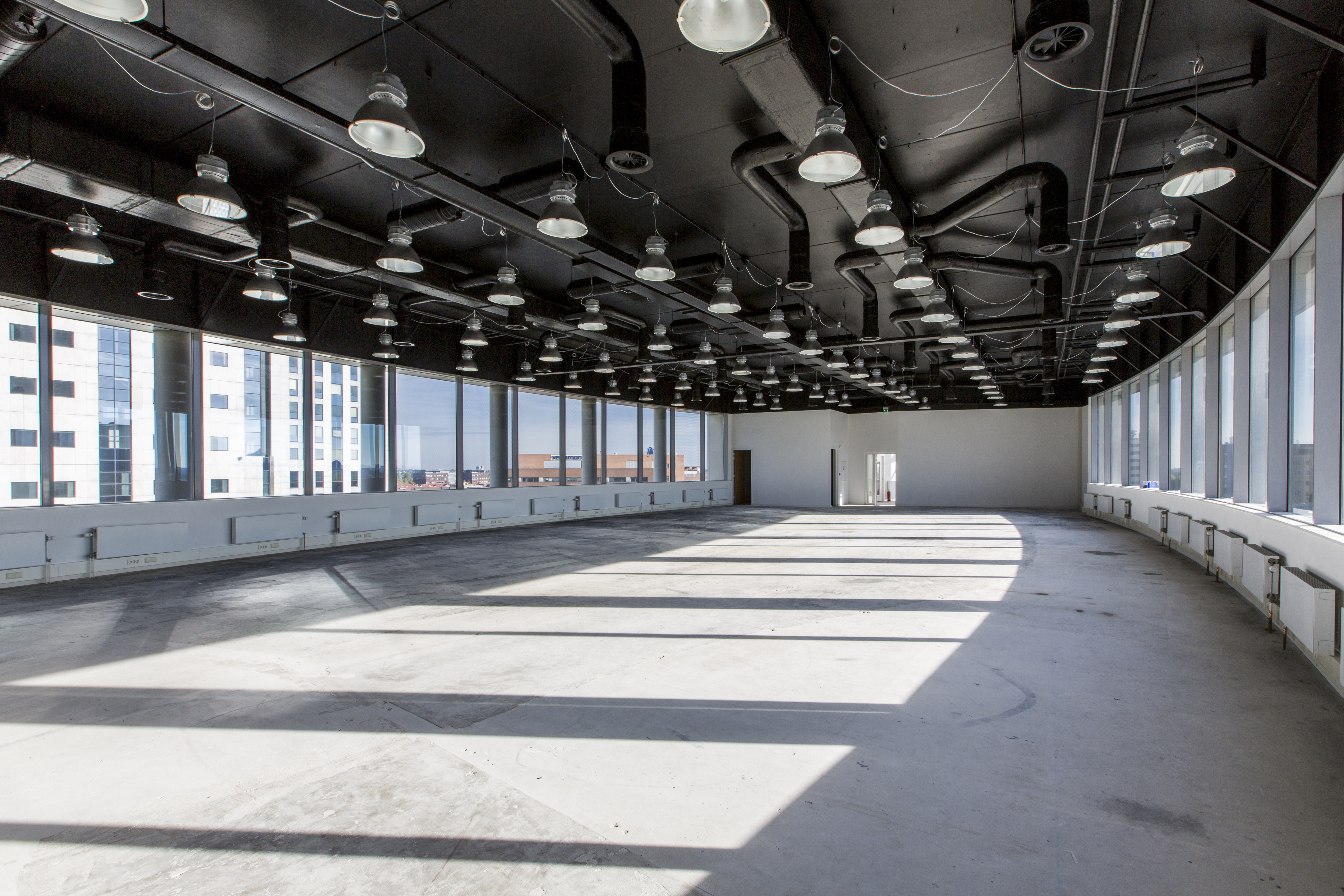 Large, bright room with concrete floor and panoramic windows, ideal for high-quality tiles.