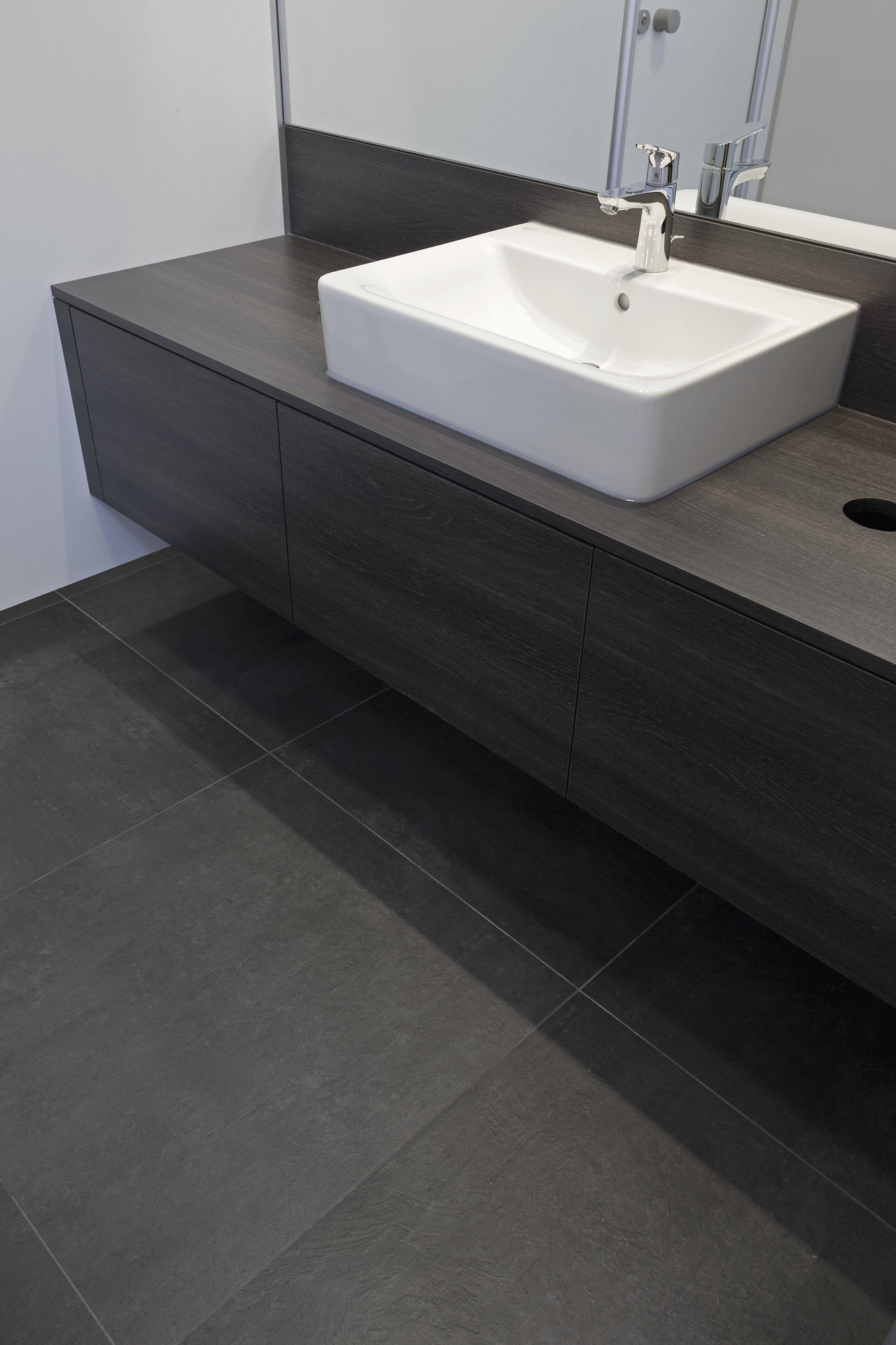 High-quality anthracite porcelain stoneware tiles in a modern bathroom.