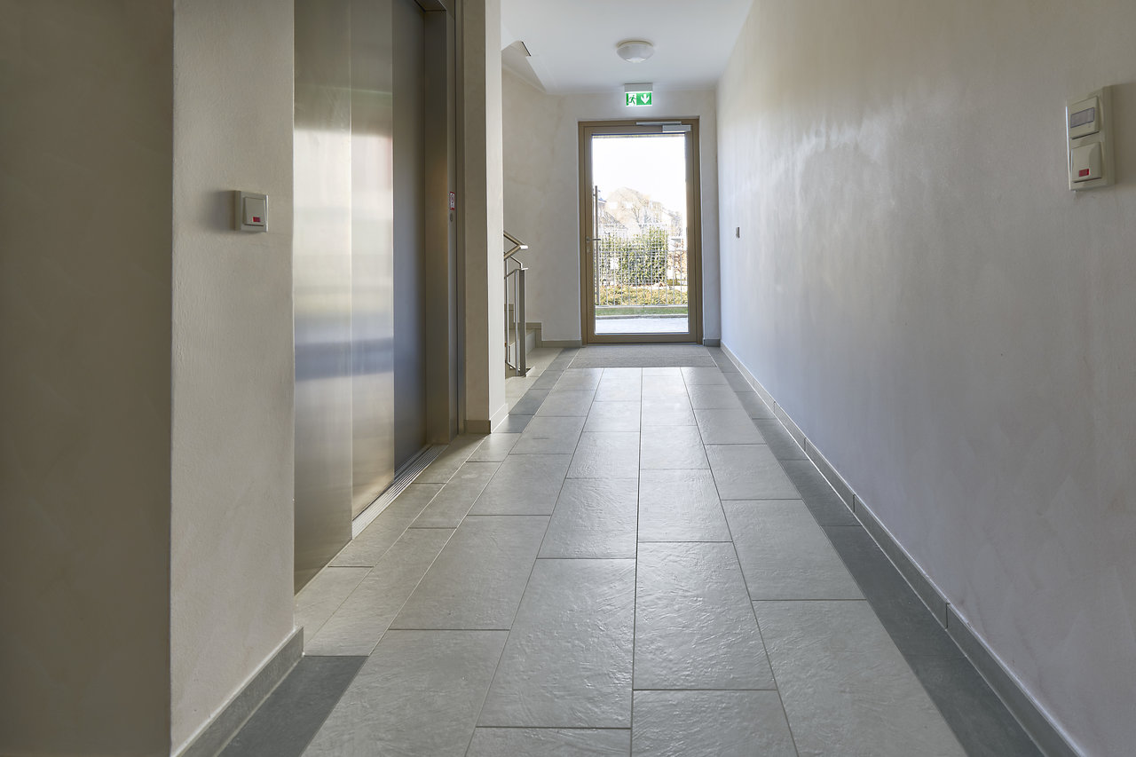 Bright hallway with hard-wearing, light grey floor tiles, ideal for entrance areas.