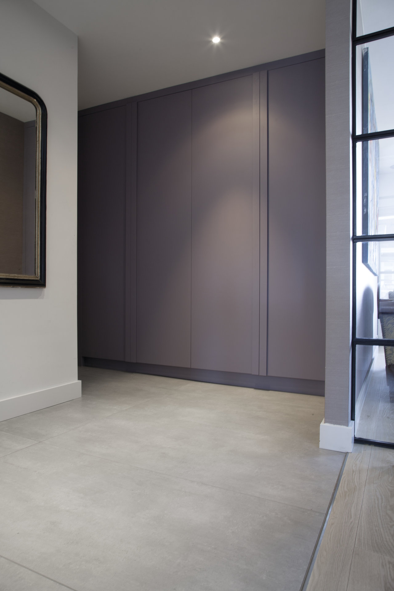 Light concrete-look porcelain stoneware tiles in a modern hallway.