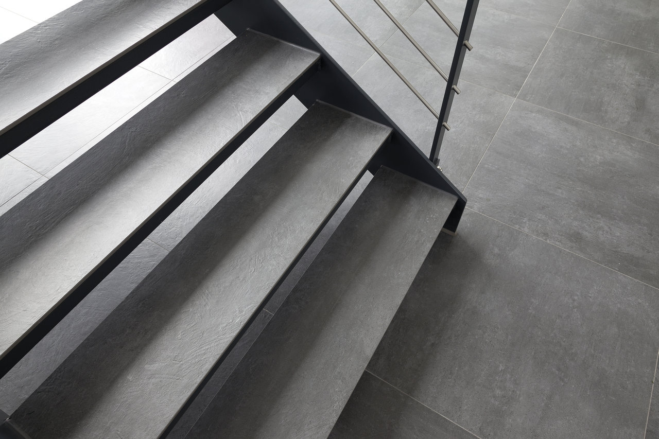 Stylish stairs and floor with large-format dark grey tiles.