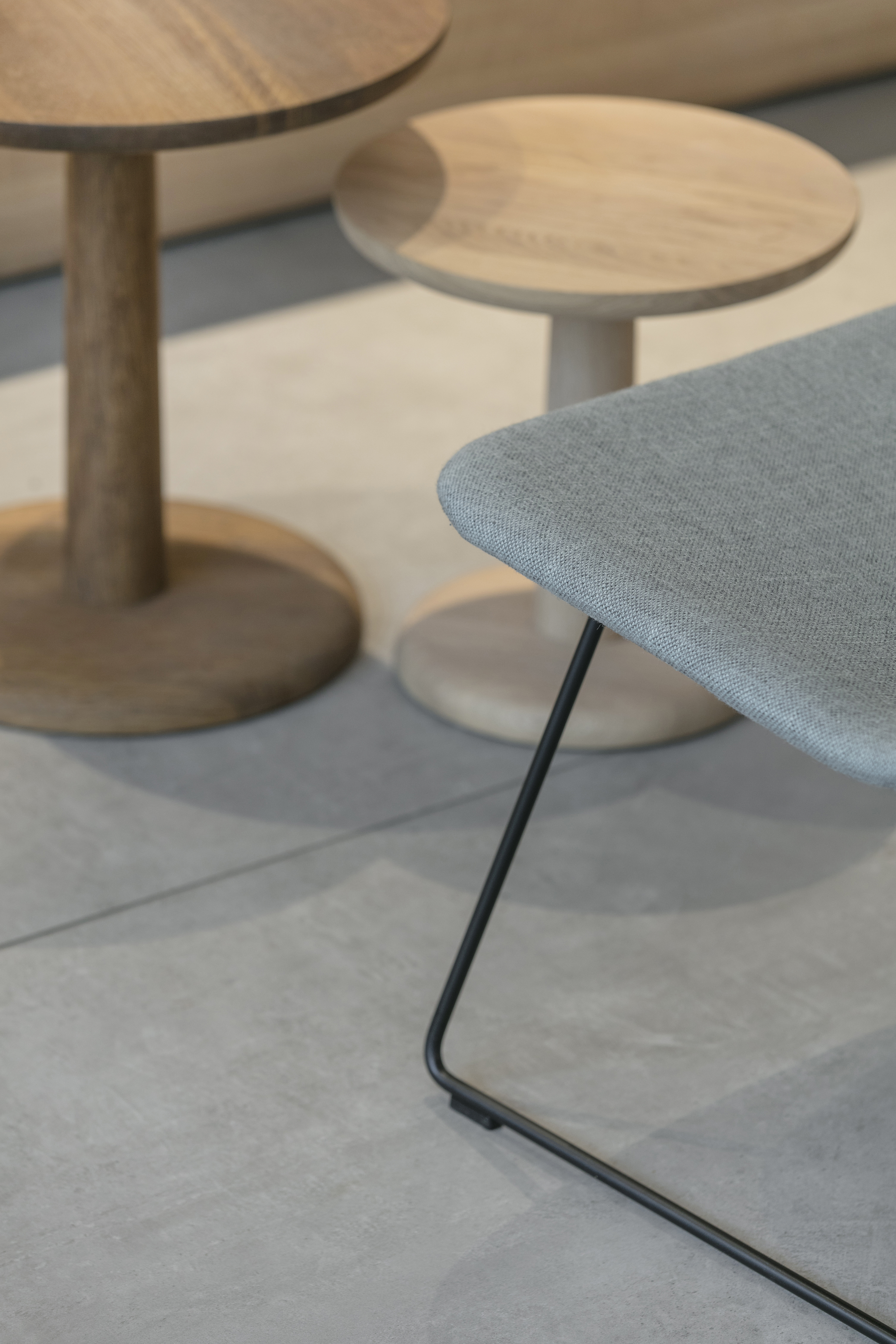High-quality grey indoor tiles with modern wooden side tables.