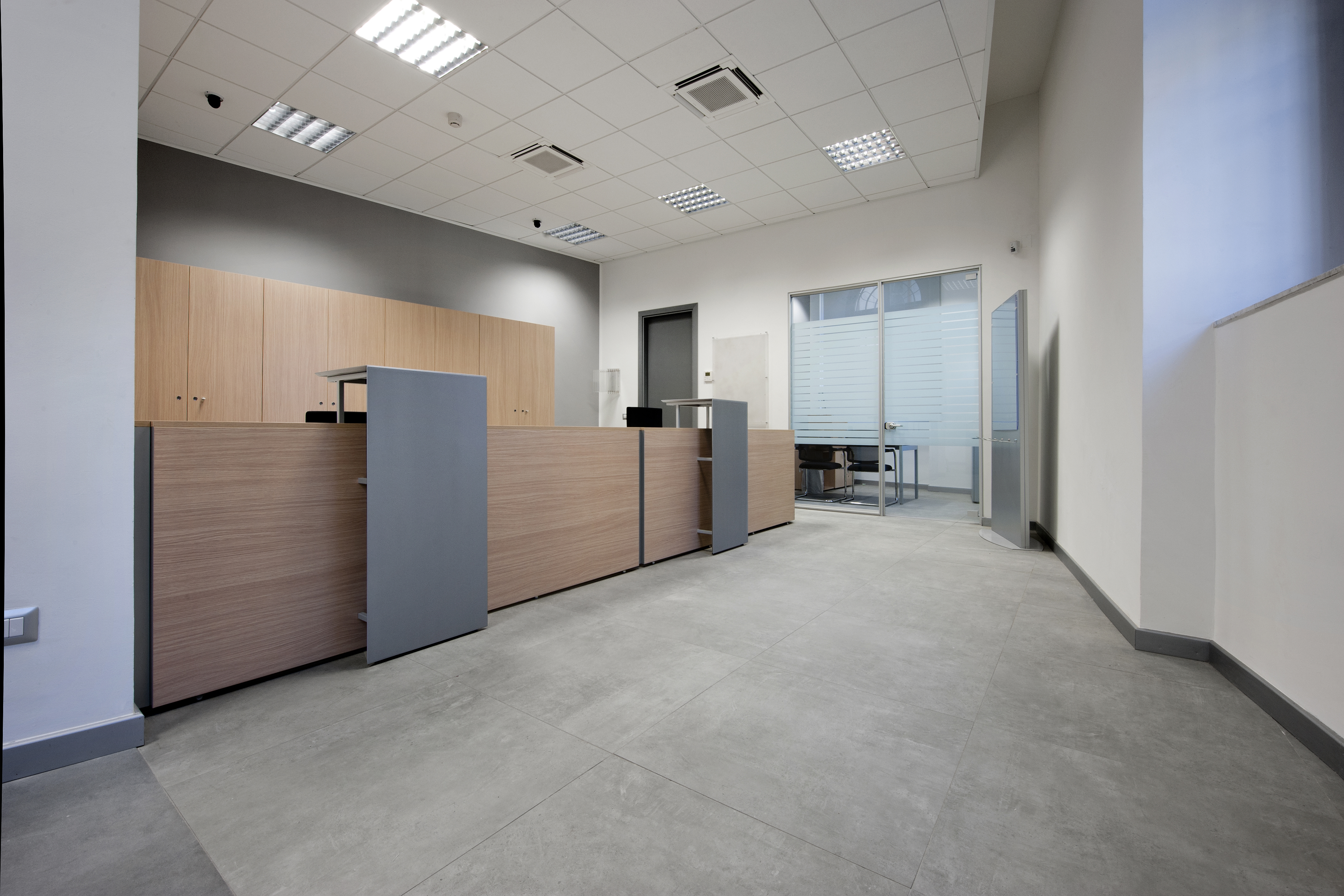 Large-format, light grey floor tiles in a modern reception area.