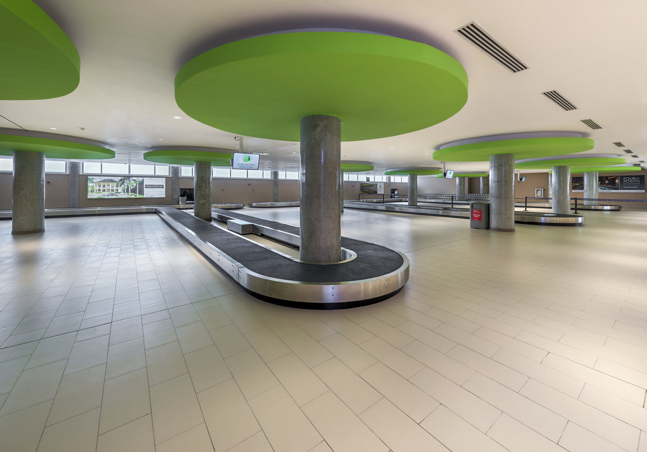 Light, durable tiles in a modern luggage hall with green accents.