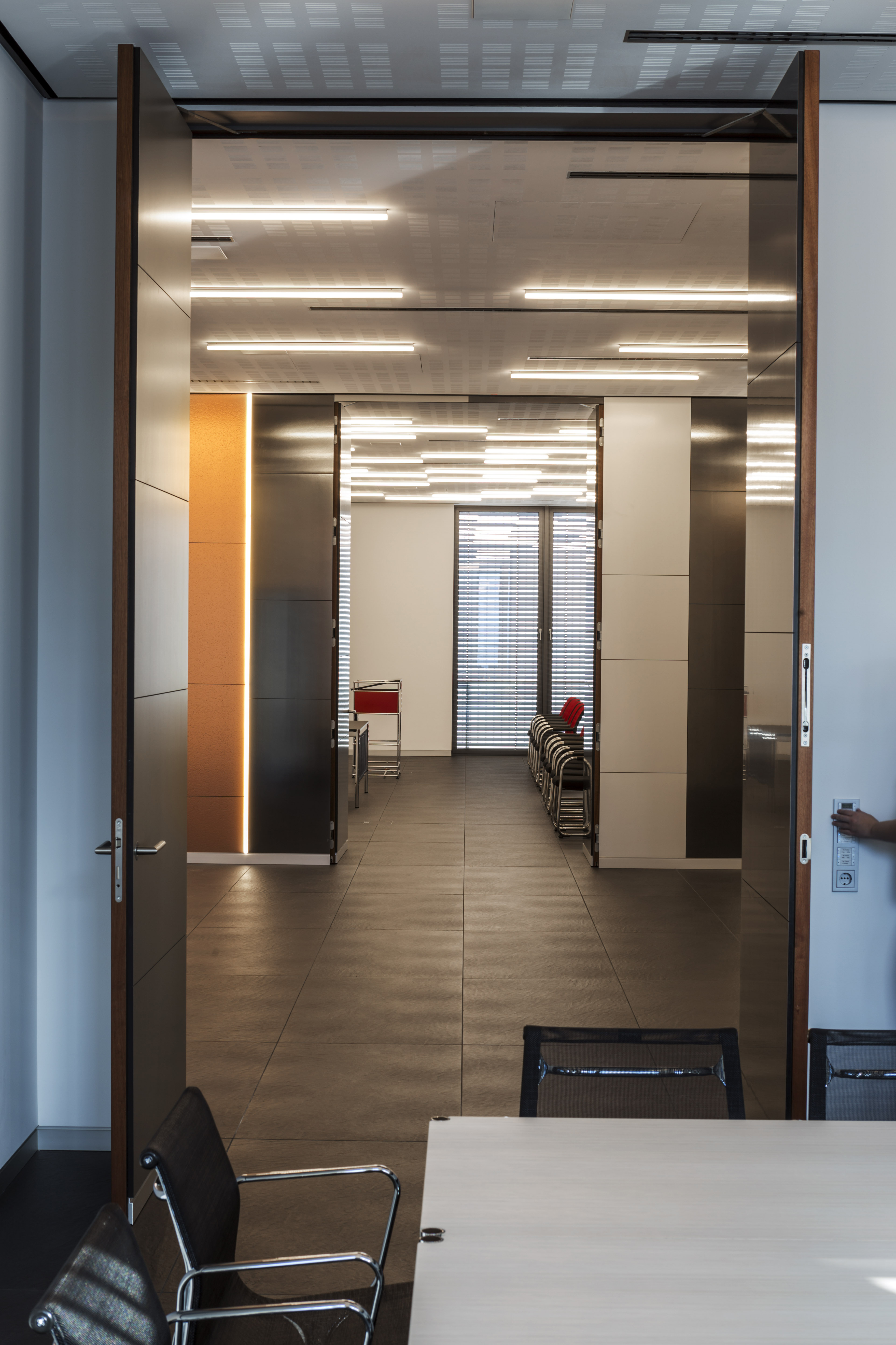 Modern hallway with dark floor tiles and stylish lighting.