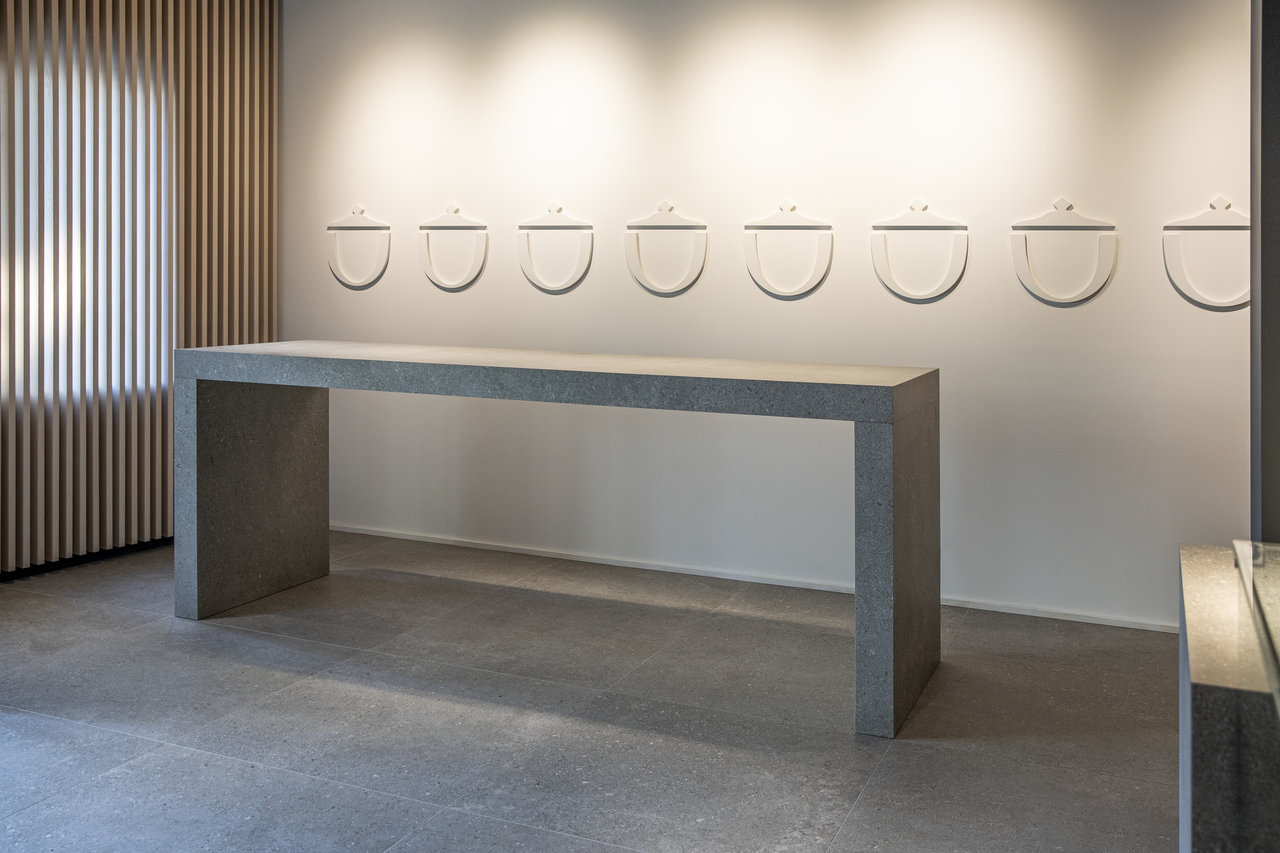 Modern tile showroom with grey floor tiles and minimalist decor.