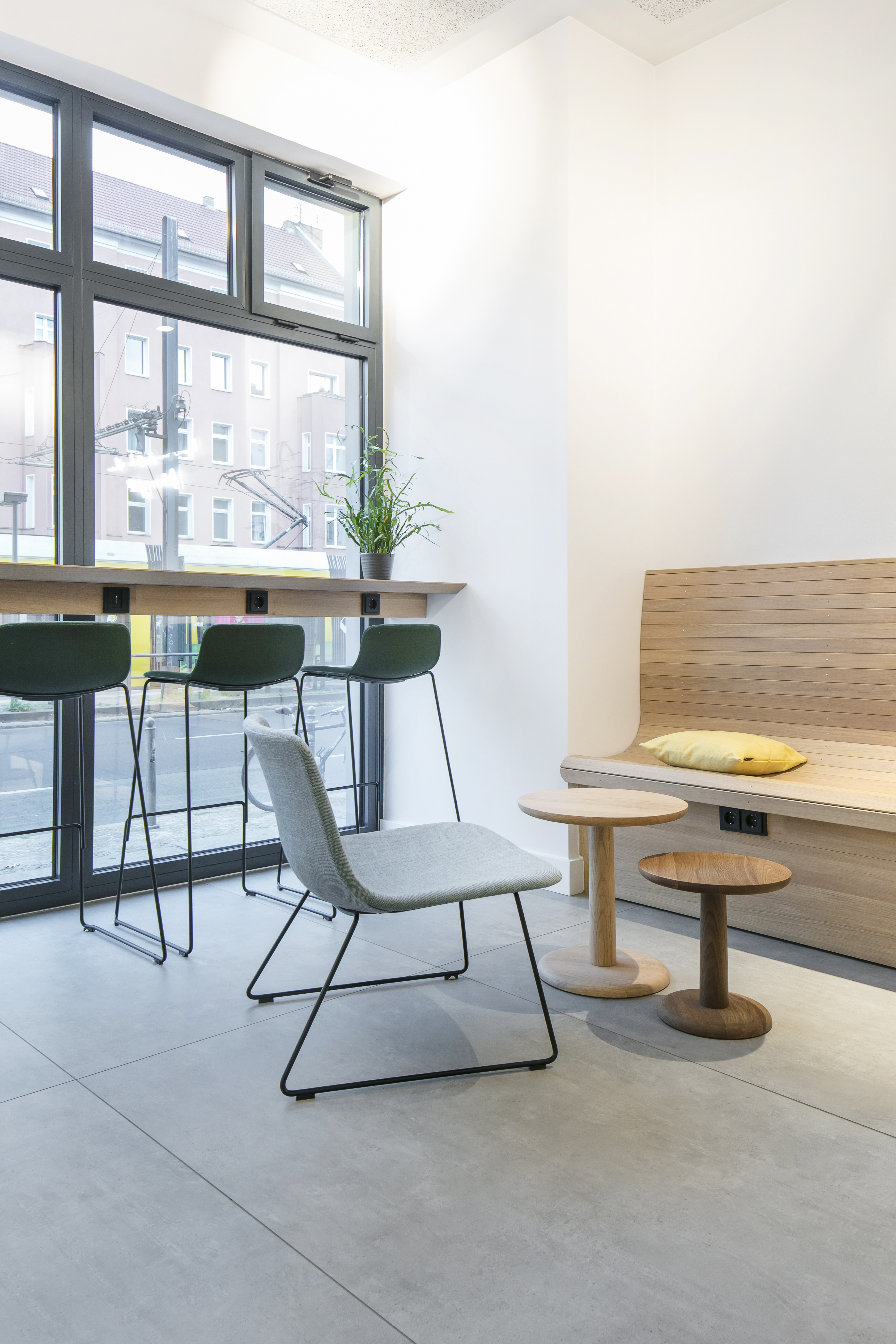 Bright, large-format tiles in a modern waiting area with wooden elements.