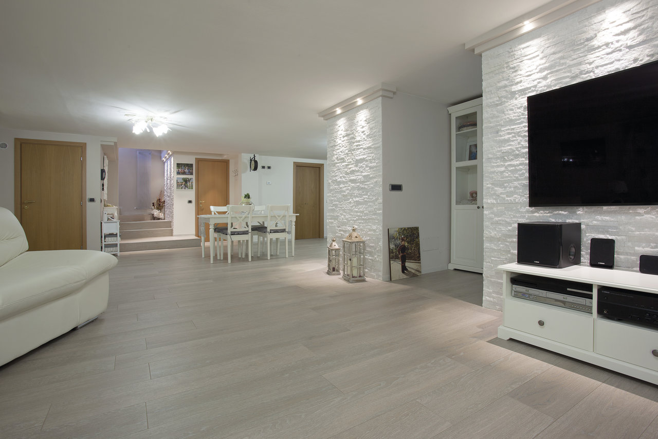 Bright living area with modern floor tiles and a white textured wall.