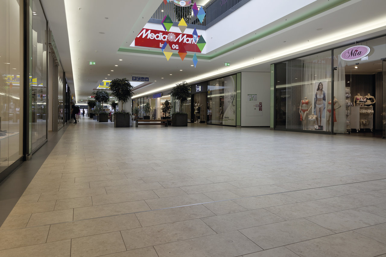 Bright, large-format floor tiles in a modern shopping centre.
