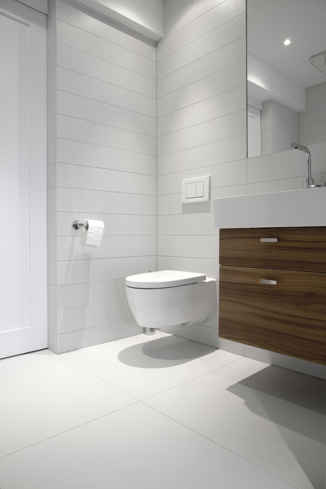 Bright, modern bathroom with white floor tiles and horizontal wall tiles.