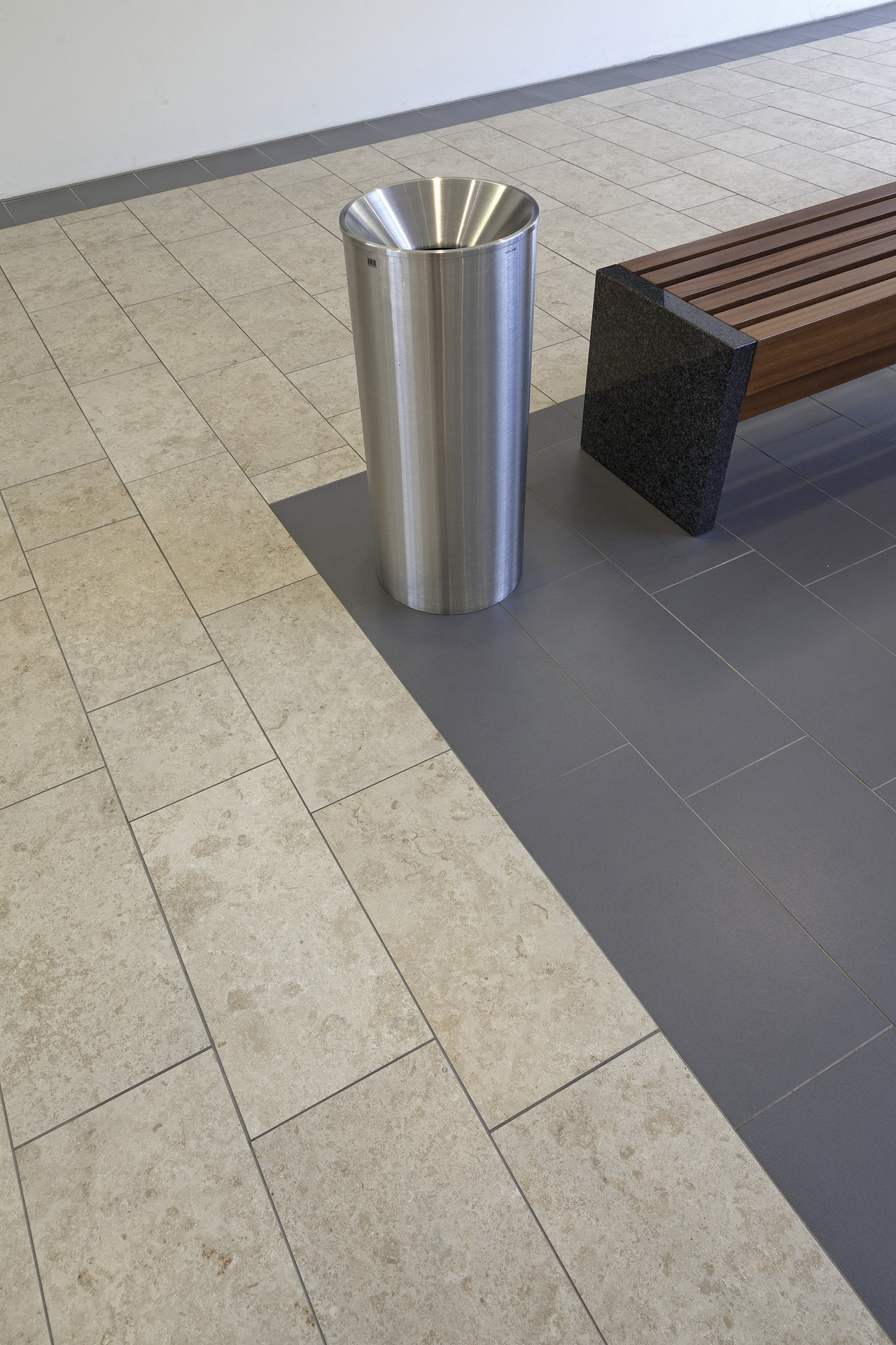 Light natural stone effect and dark large-format tiles for modern floor design.